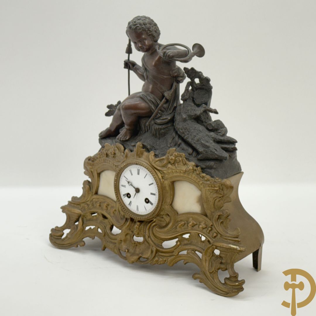 Zamak pendule met accanthusranken en bekroond met cupido met jachthoorn