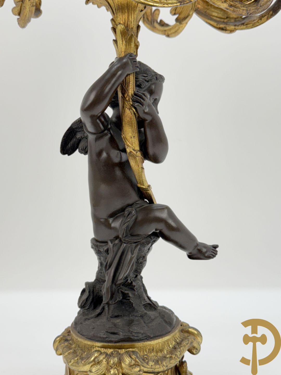 Bronzen cupido dragende een zevenarmige kandelaar