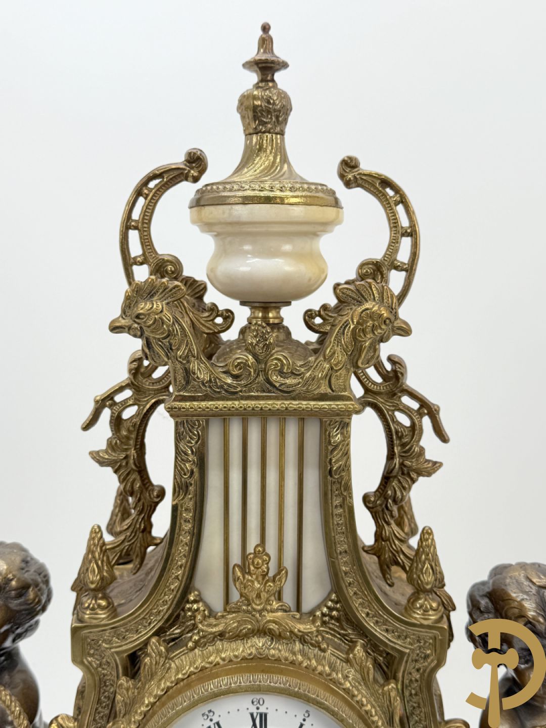 Driedelige koperen garnituur, centraal met harp geflankeerd door paar cupido