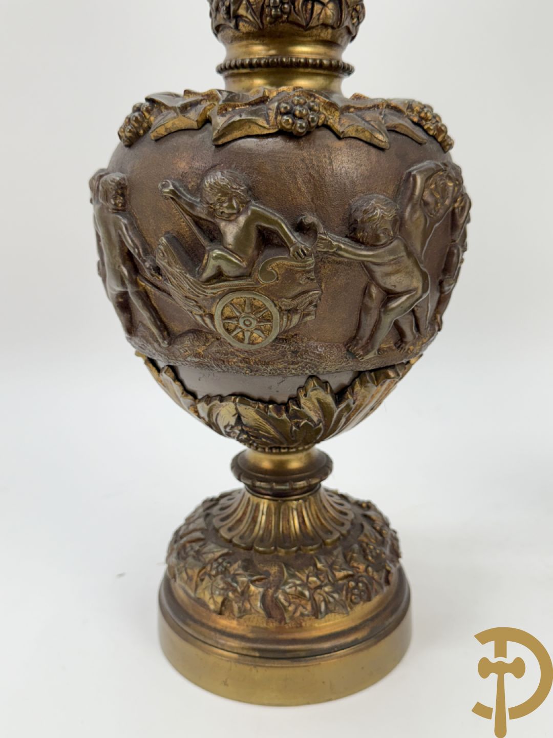 Paar bronzen schenkkannen met basrelief van putti en accanthusranken