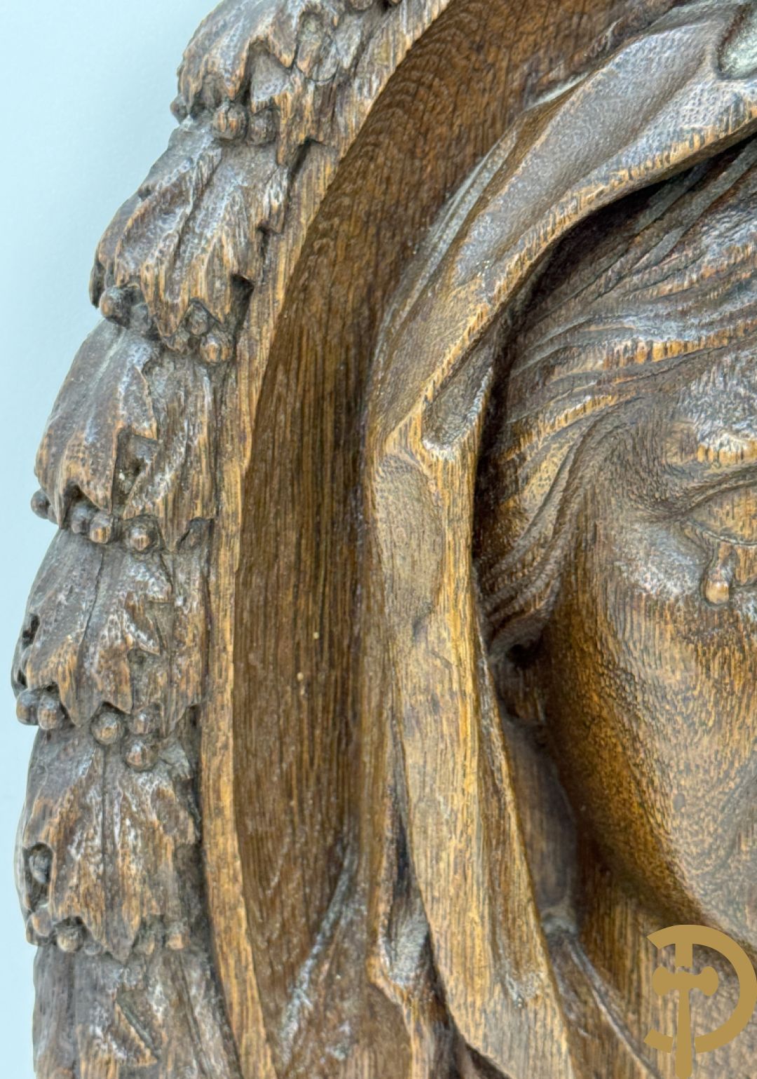 Houtgesculpteerd basrelief van wenende dame in cartouche met accanthusranken