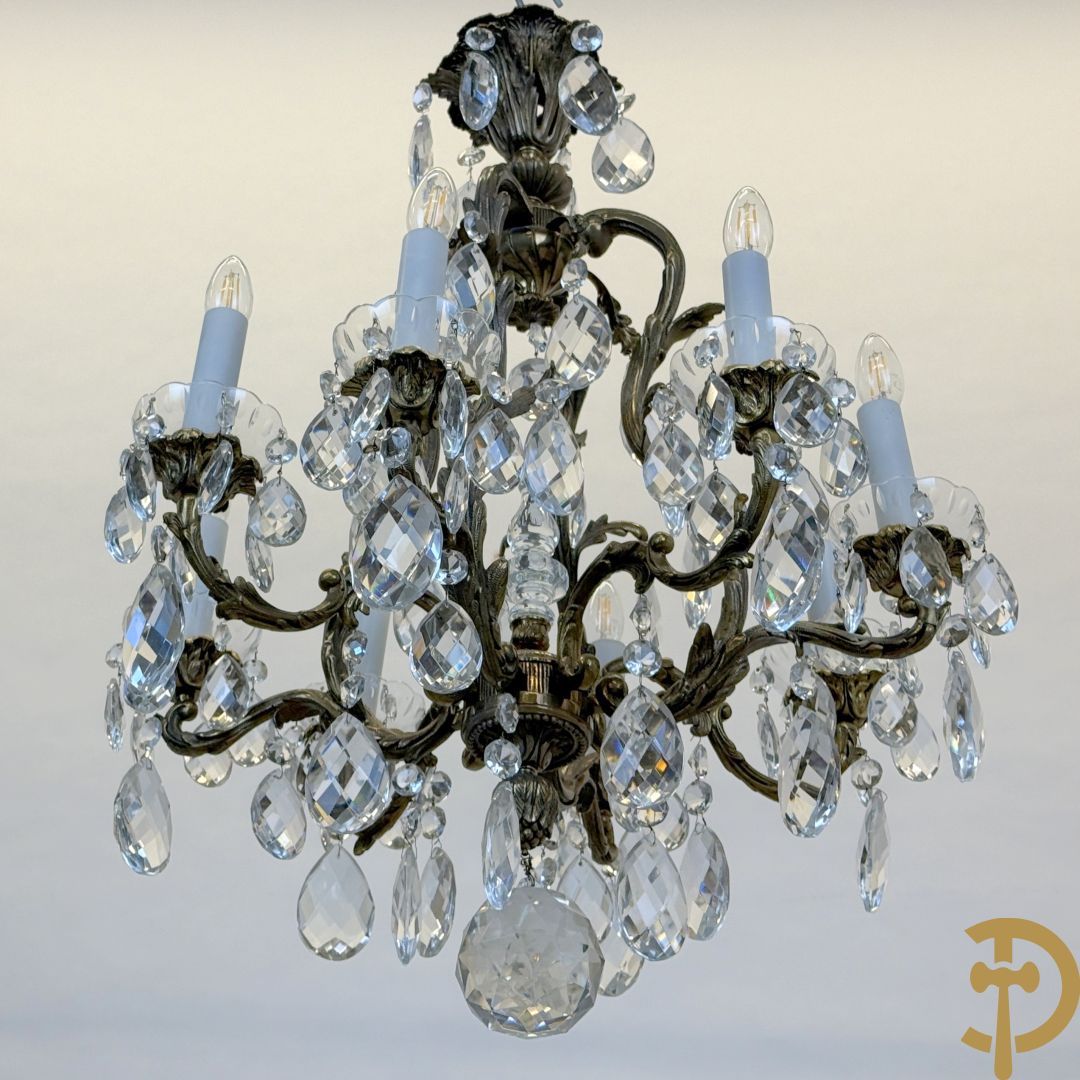 Achtarmige koperen luchter met kristallen bellen en binnenin met pinakel bezet