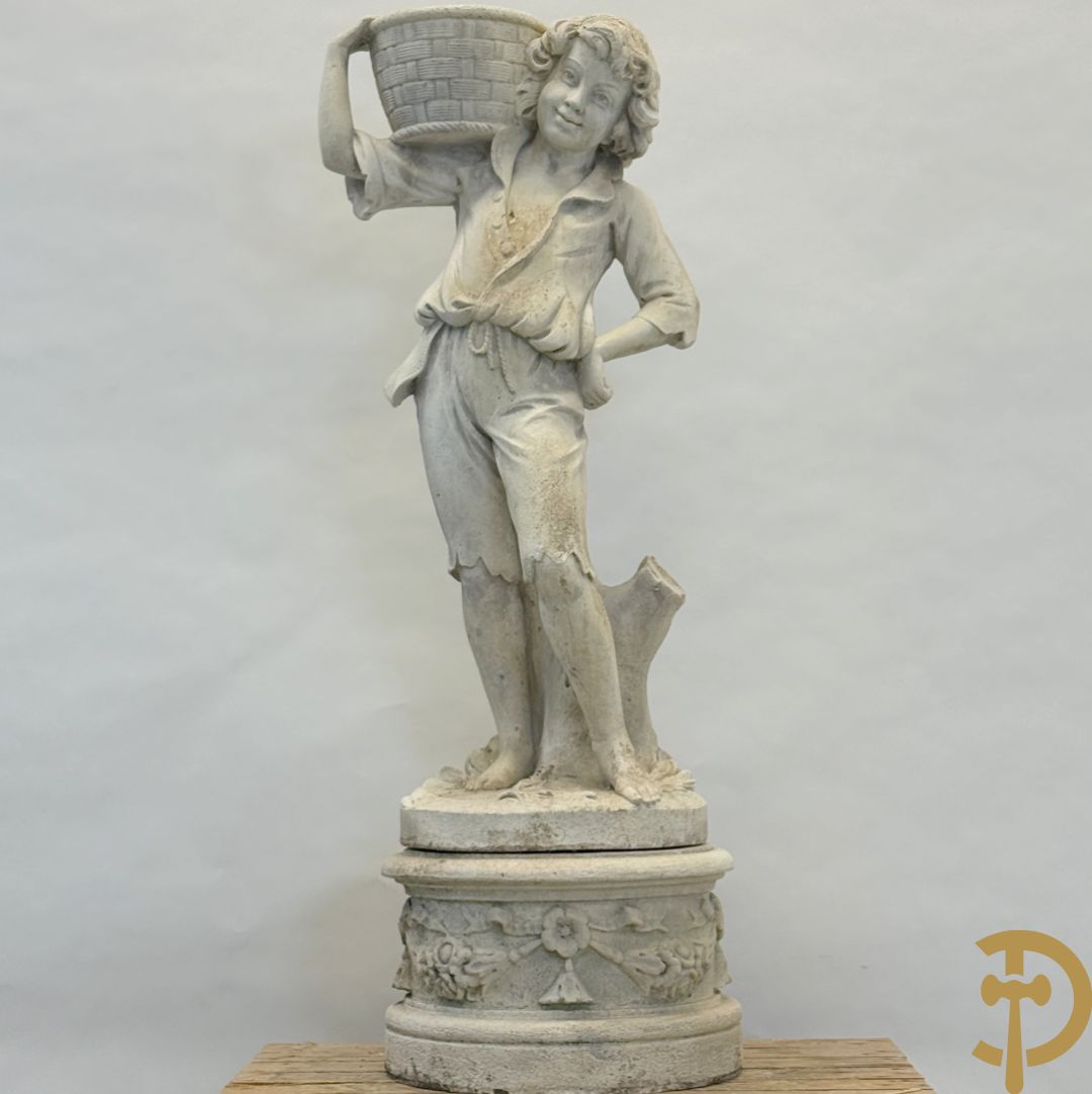 Stenen tuinbeeld van jongeman met mand in de hand op sokkel met guirlandes