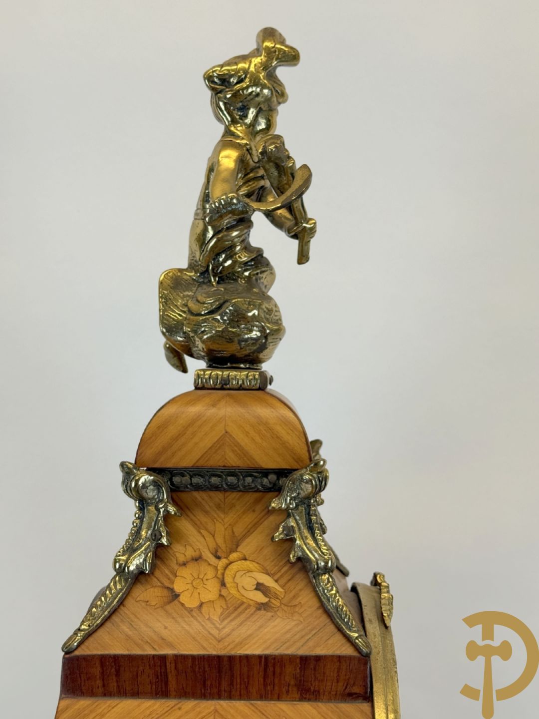 Notelaren pendule met bloemenmarquetterie en bronsbeslag, bovenaan bekroond met bronzen figuur - met bijhorende sokkel in notelaar met bronsbeslag
