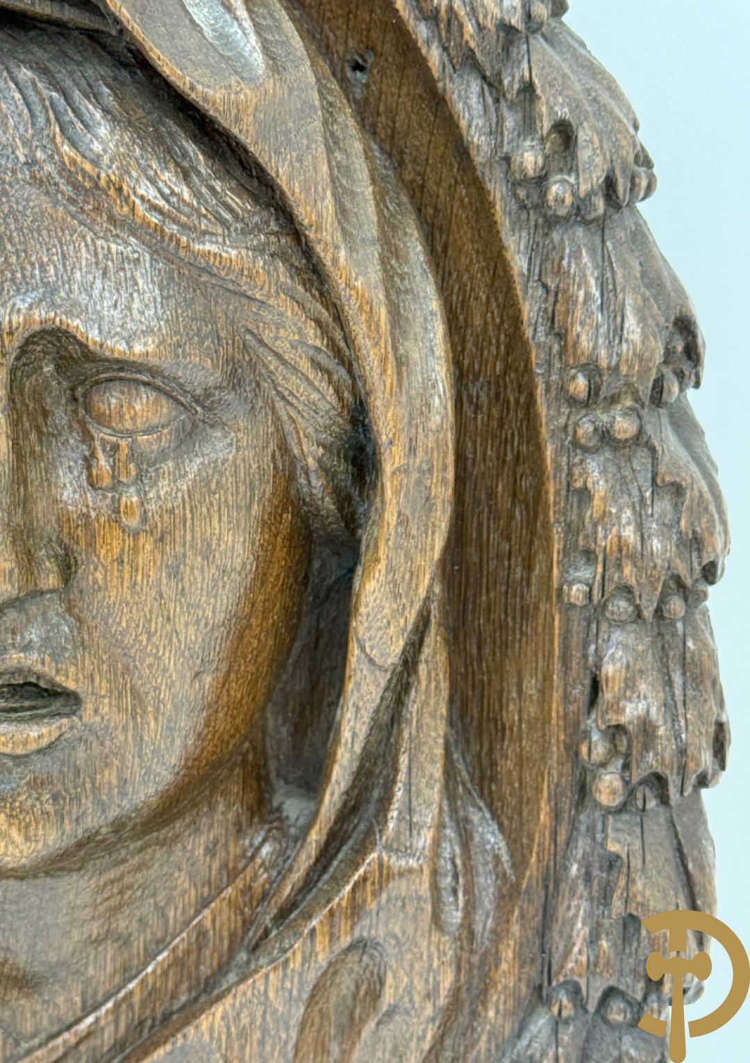 Houtgesculpteerd basrelief van wenende dame in cartouche met accanthusranken