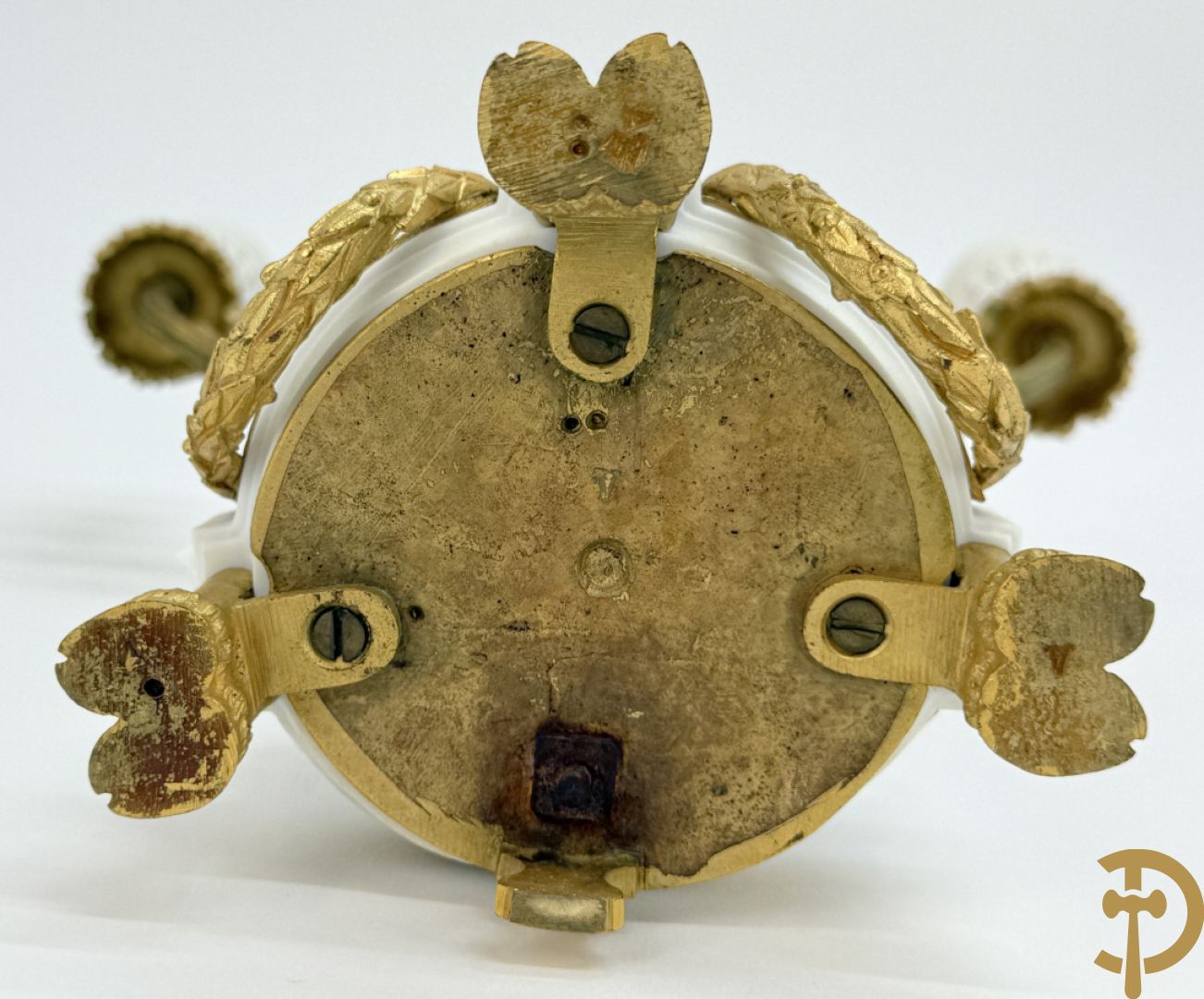 Driedelige porseleinen garnituur met bronsbeslag bestaande uit pendule met dame en amfoor geflankeerd door paar kandelaars bezet met personages