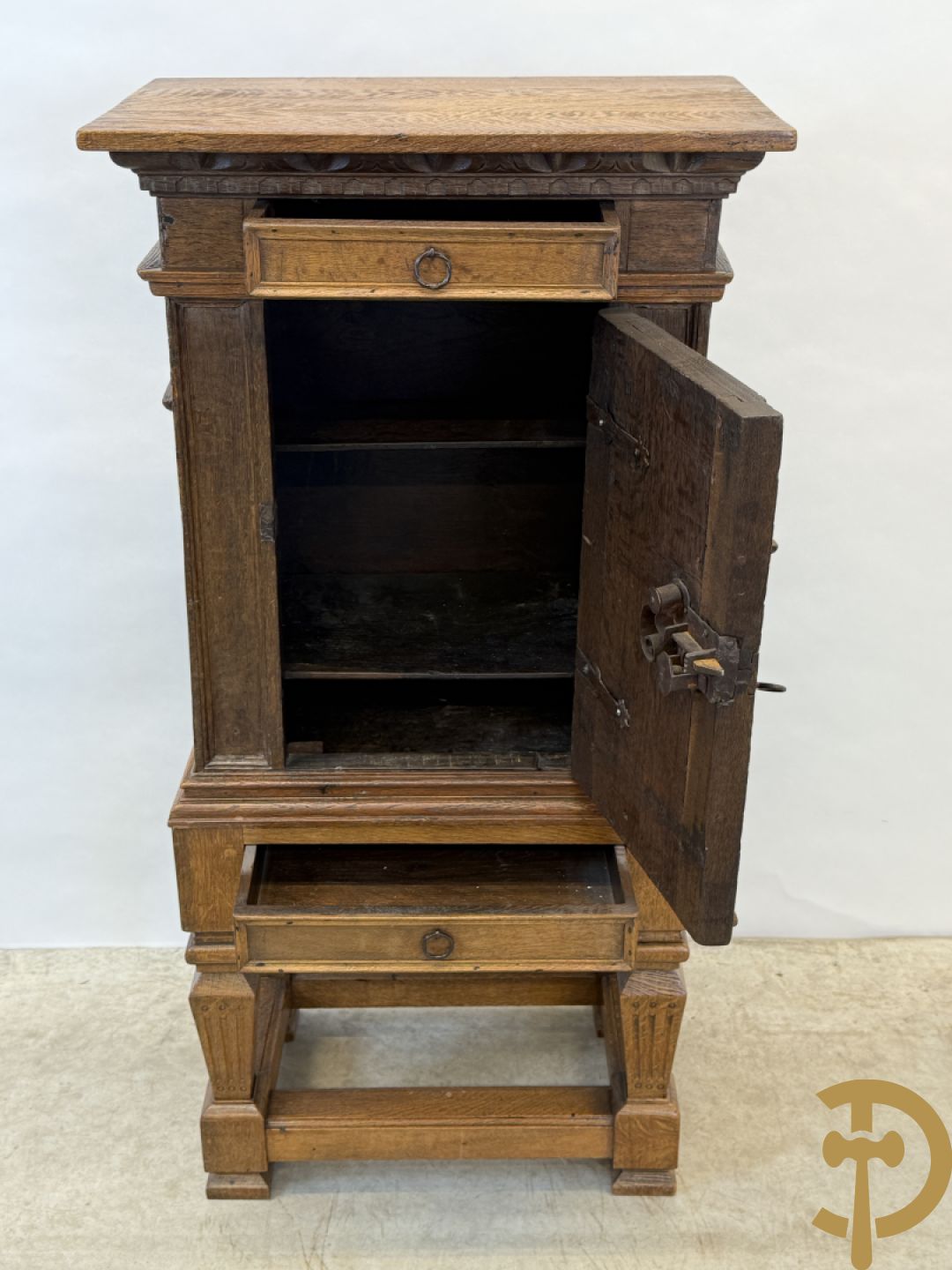 Massief eiken ééndeurskast op onderstel met lade bovenaan, lade onderaan, sculptuur in zijkant en deur