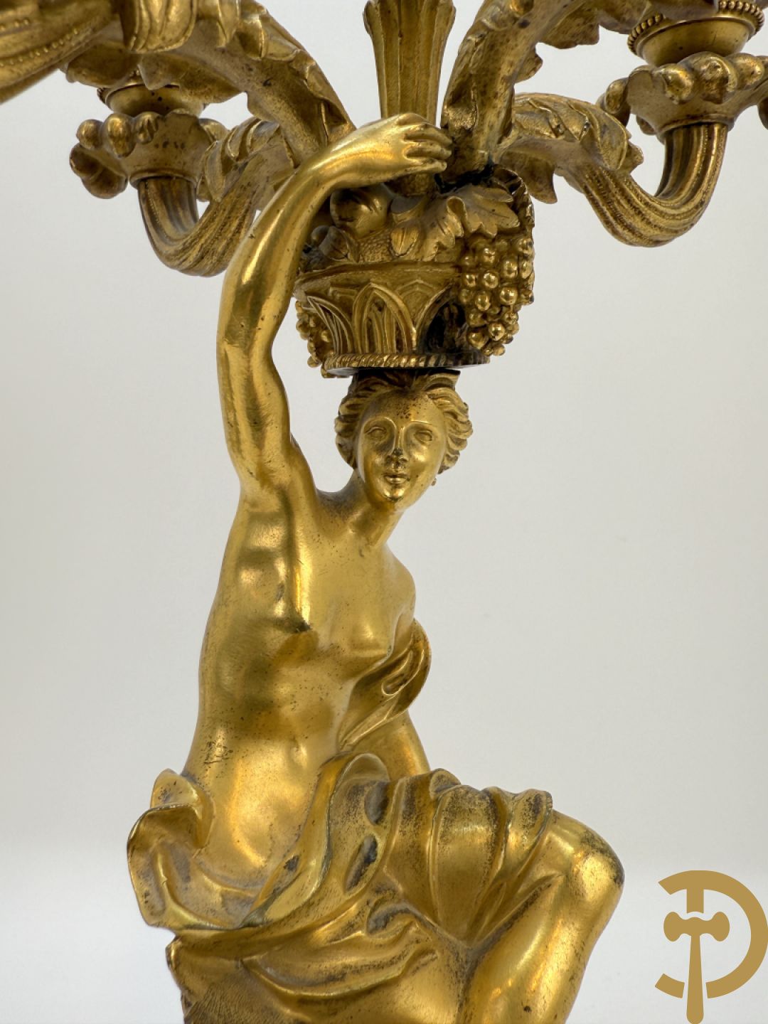 Paar bronzen kandelaars met sater en naakte dame, versierd met accanthusranken en dierenmotieven