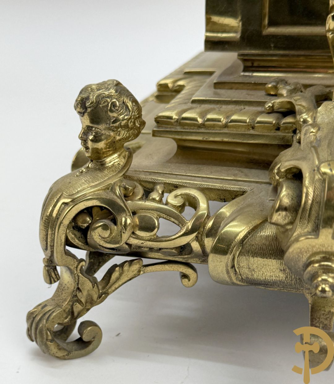 Driedelige bronzen vergulde garntiuur bestaande uit klok met medusahoofden en sfinxen, geflankeerd door paar zevenarmige kandelaars met accanthusranken en sfinxen