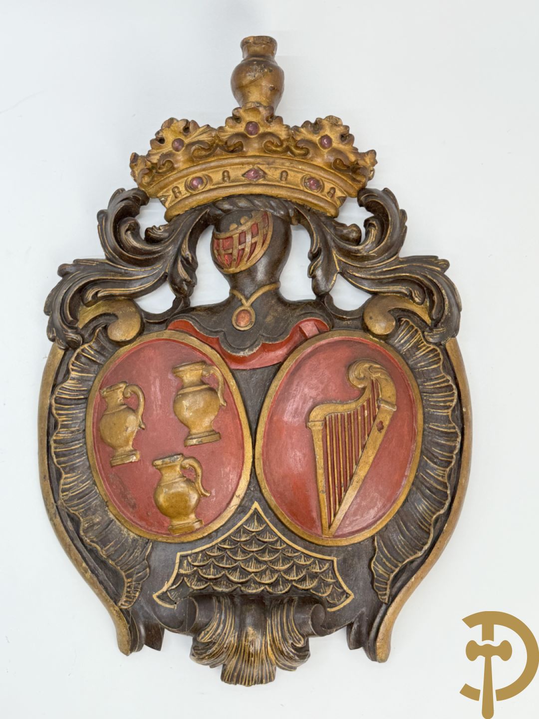 Houtgesculpteerd wapenschild met cartouche bovenaan en embleem met kannen en harp