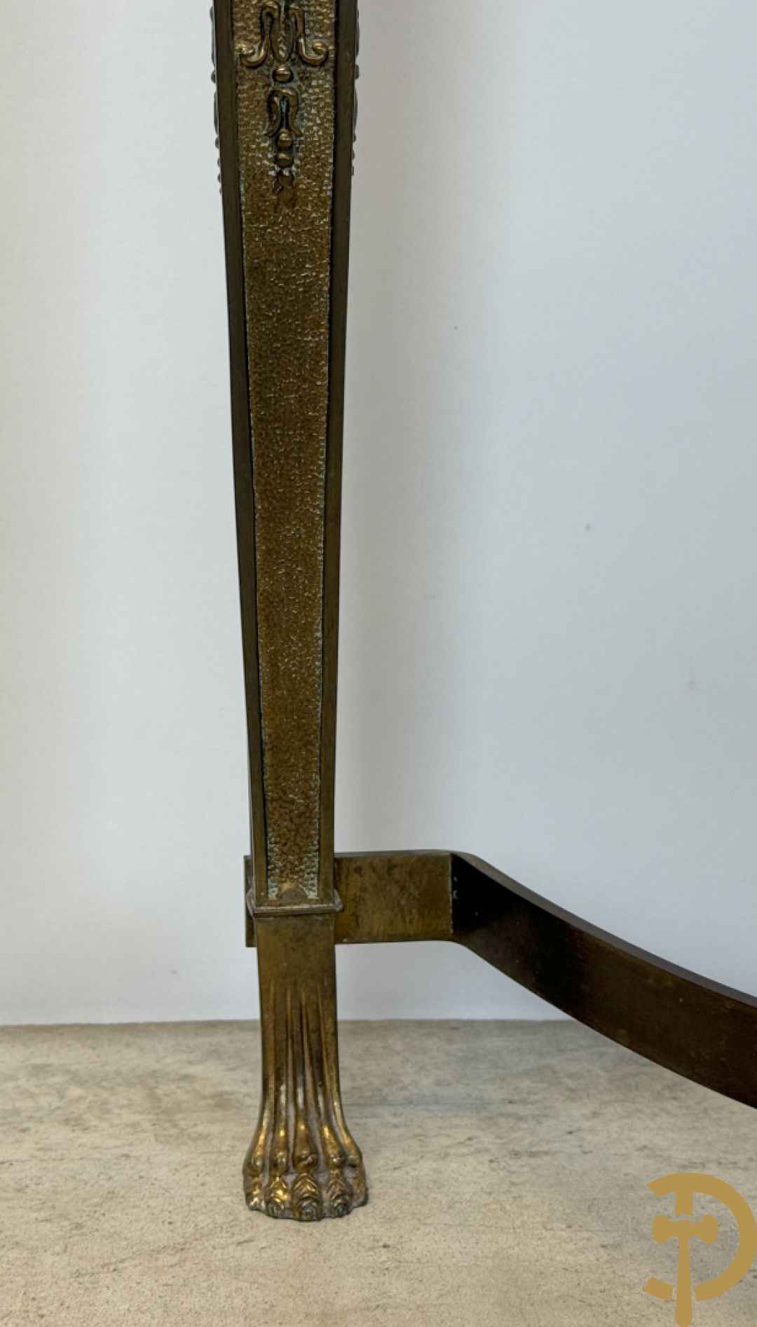 Console op bronzen poten met dameshoofden bezet, bovenaan met groen marmeren blad