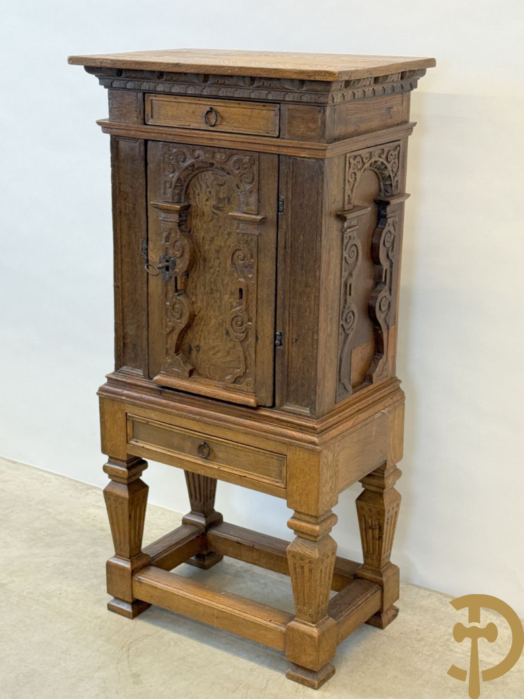 Massief eiken ééndeurskast op onderstel met lade bovenaan, lade onderaan, sculptuur in zijkant en deur