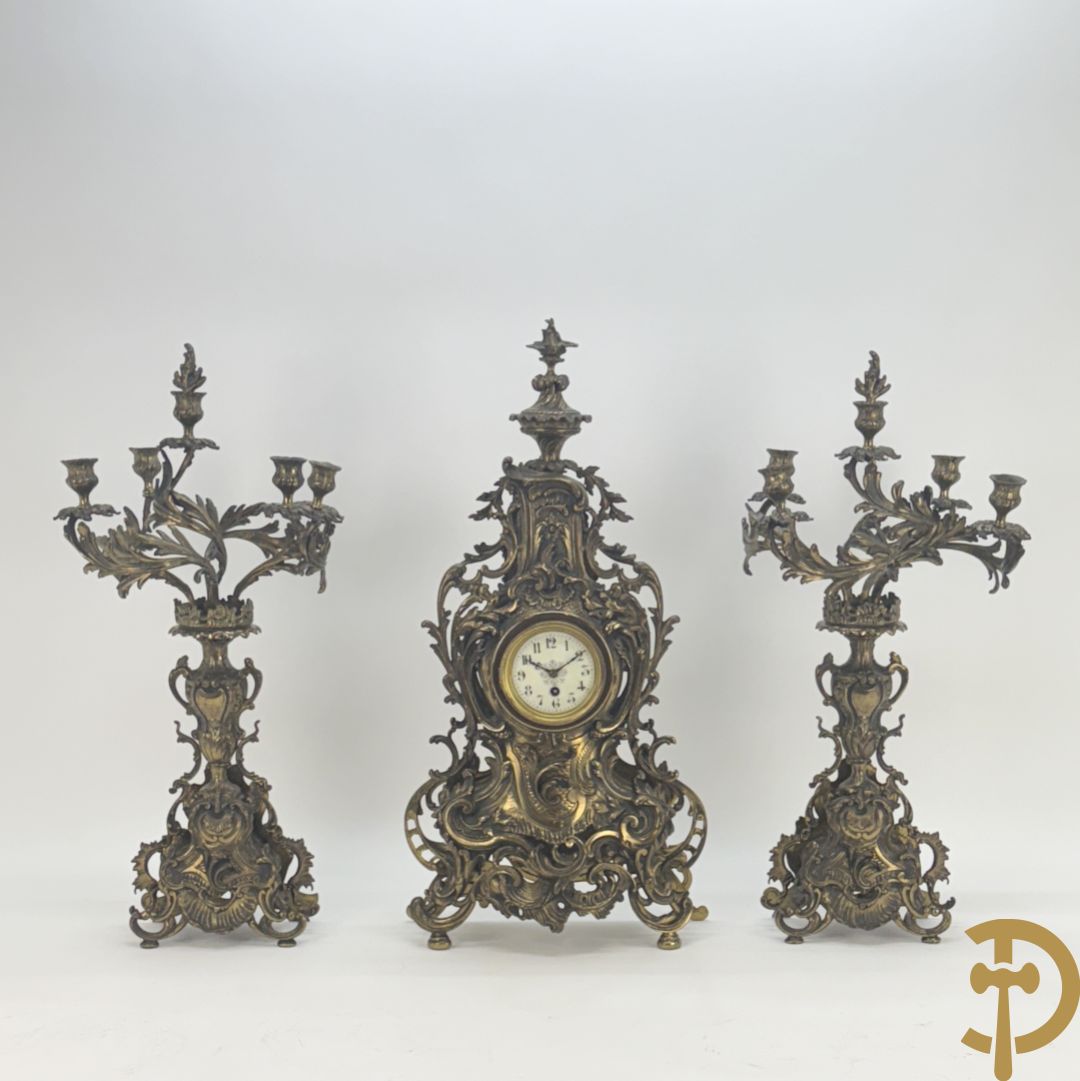 Driedelige koperen garnituur bestaande uit middenstuk bezet met amfoor en paar kandelaars , Louis XV stijl