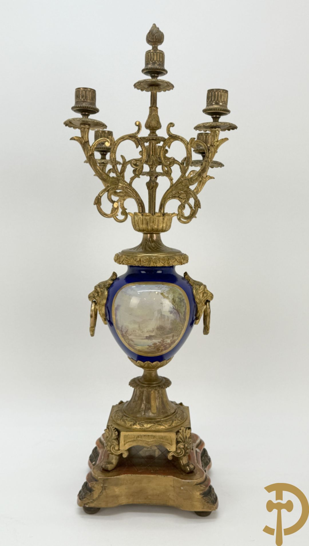 Driedelige vergulde bronzen garnituur bestaande uit pendule met blauw porseleinen coupe geflankeerd door 2 cupido