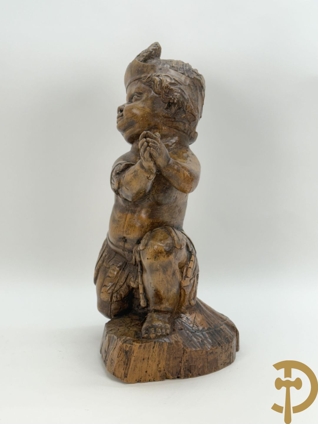 Houtgesculpteerde cupido met gevouwen handen en pluimen