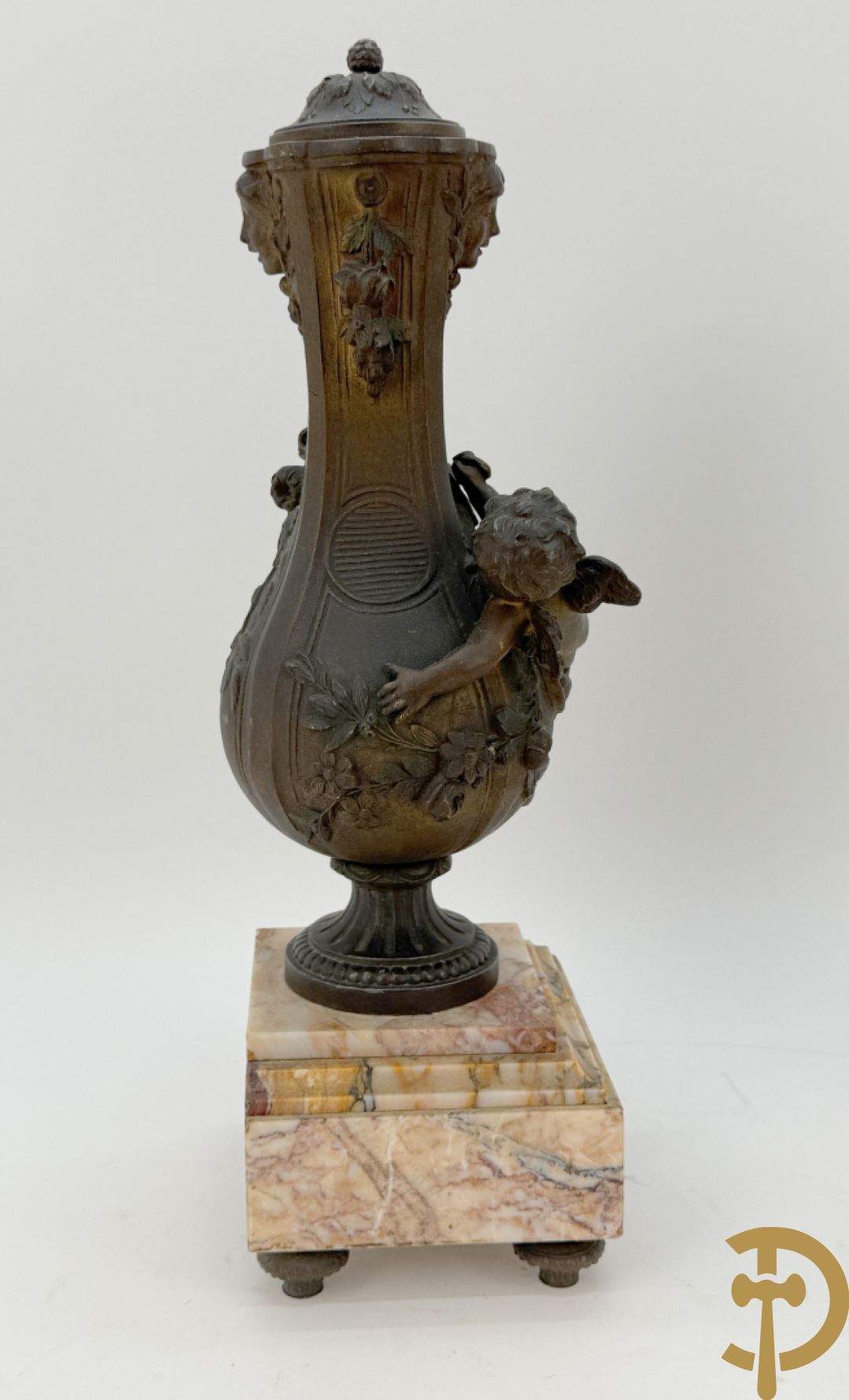 Driedelige kunstbronzen garnituur bestaande uit klok met liggende dame met amfoor op marmeren basis, geflankeerd door paar cassolettes met cupido