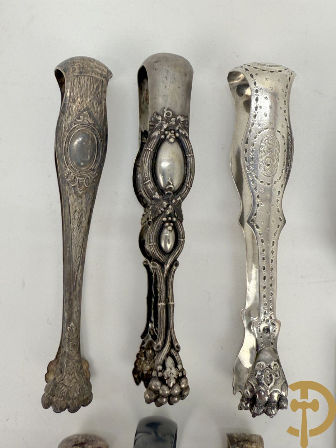 Drie massief zilveren suikertangen + 3 verzilverde suikertangen + lepel met Neo Renaissance motieven + mesje in houder