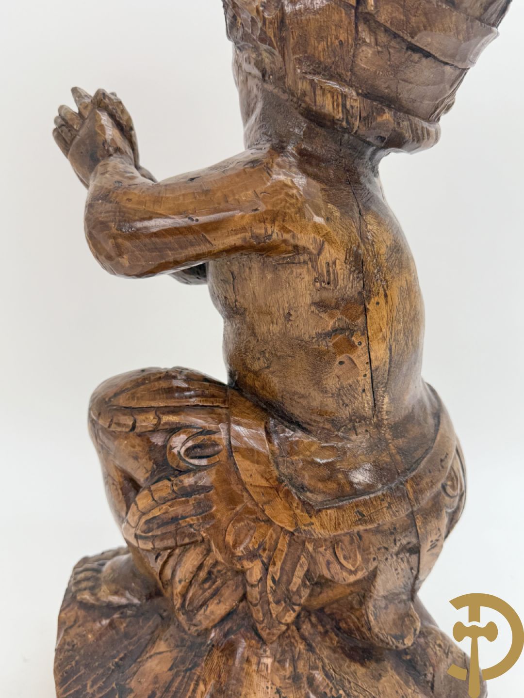 Houtgesculpteerde cupido met gevouwen handen en pluimen