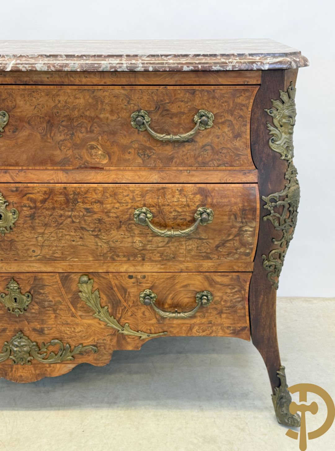 Wortelnotehouten drieladencommode met bronsbeslag van mazarinkoppen en accanthusranken, bovenaan met rood geaderd marmeren blad