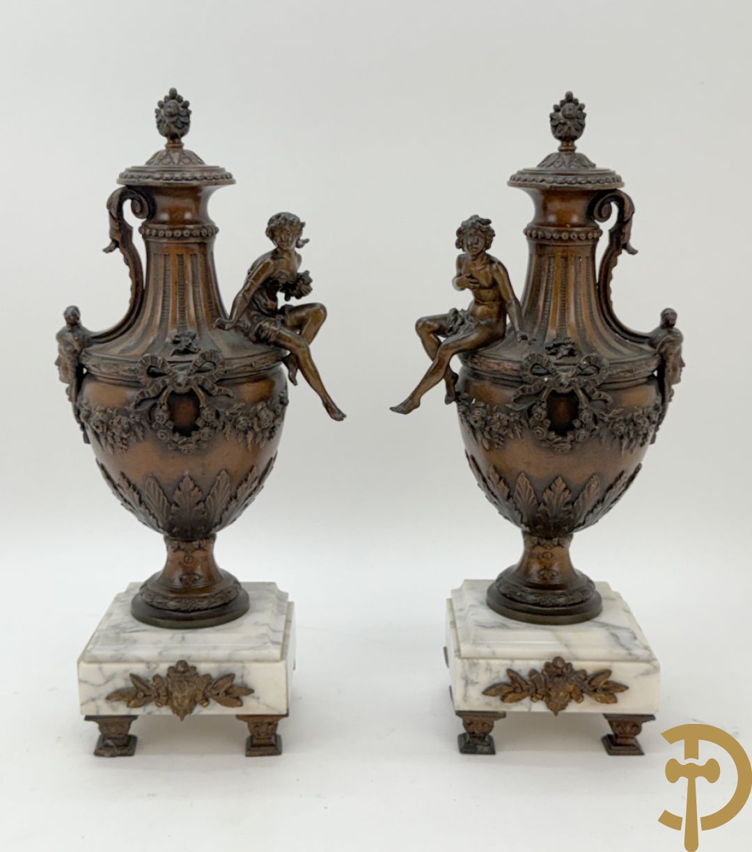 Driedelige schouwgarnituur met centrale pendule met liggende dame en cupido, geflankeerd door paar cassolettes met elegante dame
