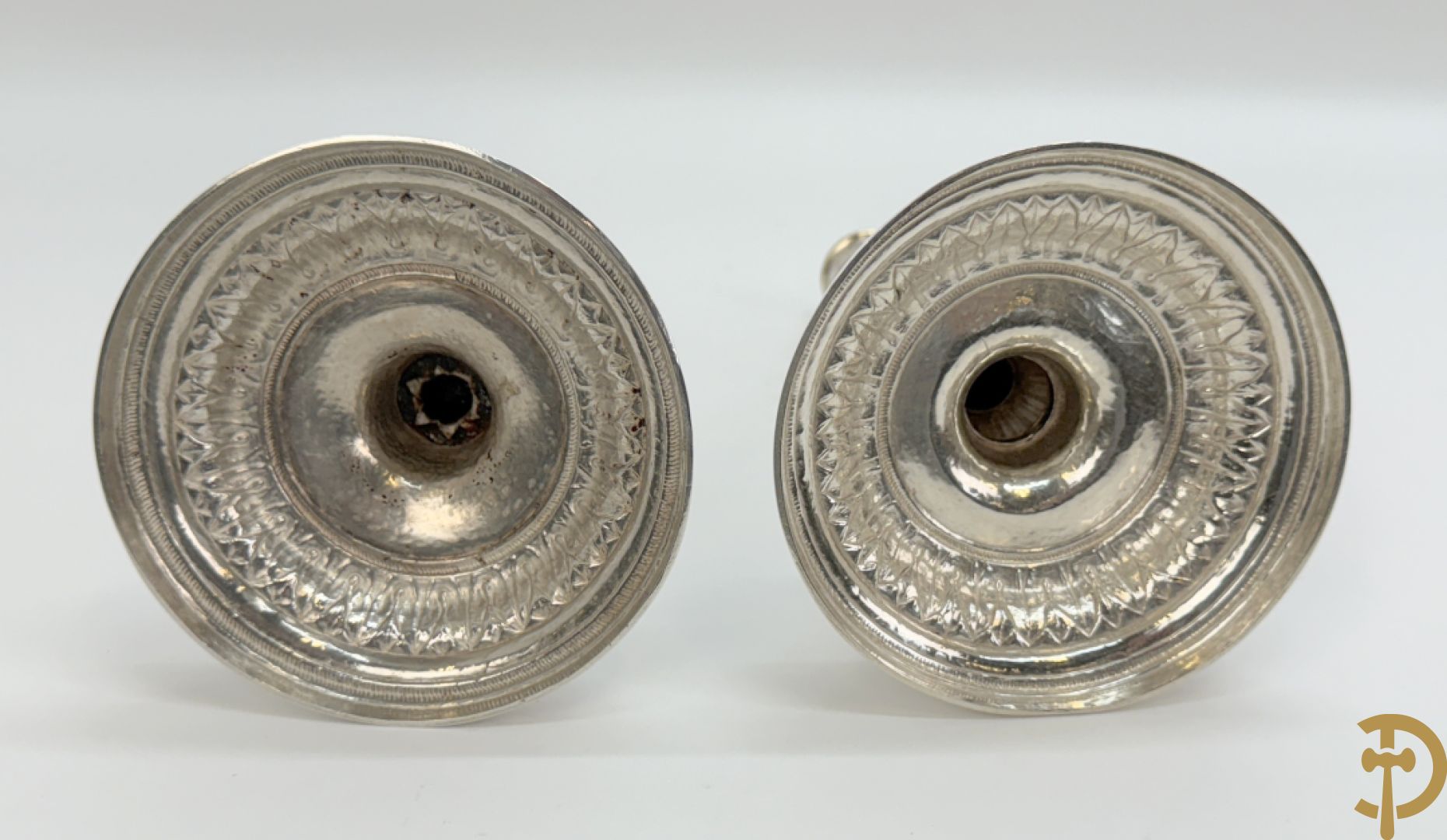 Paar massief zilveren kandelaars met gestyleerd bloemenmotief, één ervan gemerkt met stempel van Jan Baptist Verberckt, andere kandelaar met verschillende stempels met o.a. Antwerpen 1784
