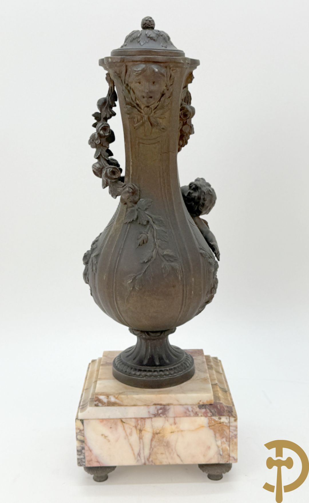 Driedelige kunstbronzen garnituur bestaande uit klok met liggende dame met amfoor op marmeren basis, geflankeerd door paar cassolettes met cupido