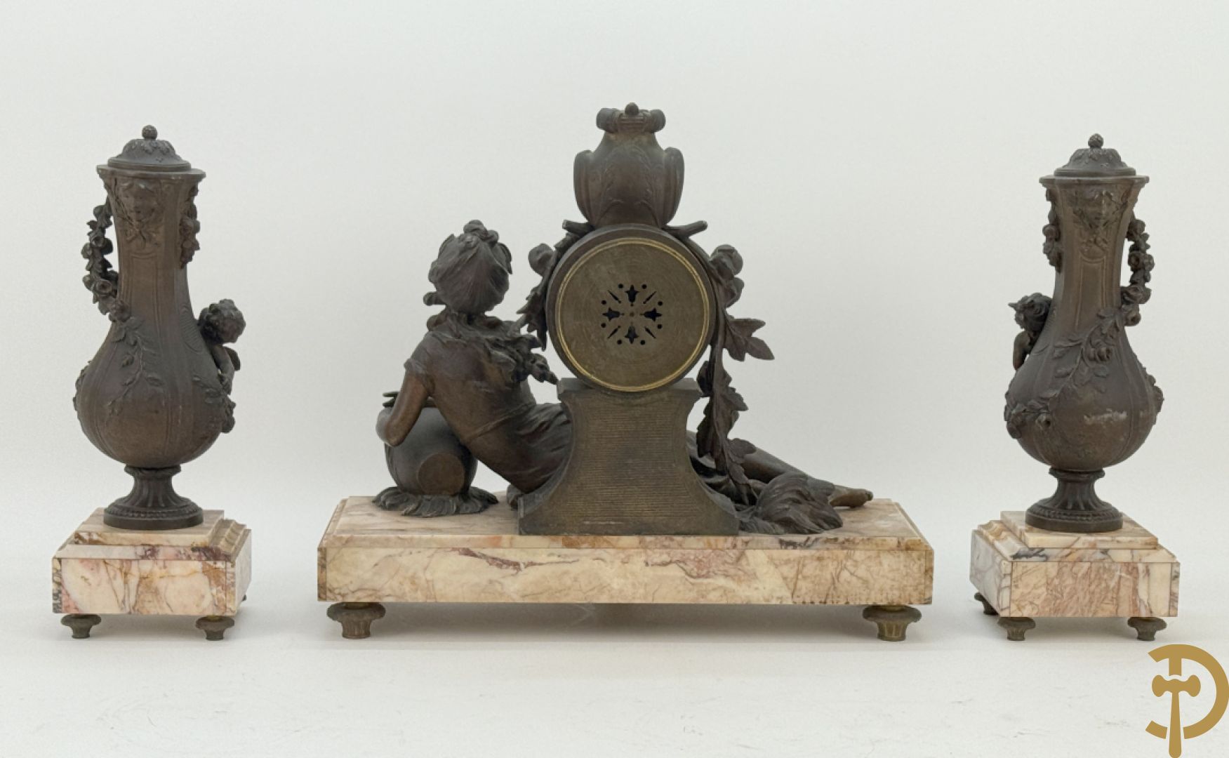 Driedelige kunstbronzen garnituur bestaande uit klok met liggende dame met amfoor op marmeren basis, geflankeerd door paar cassolettes met cupido