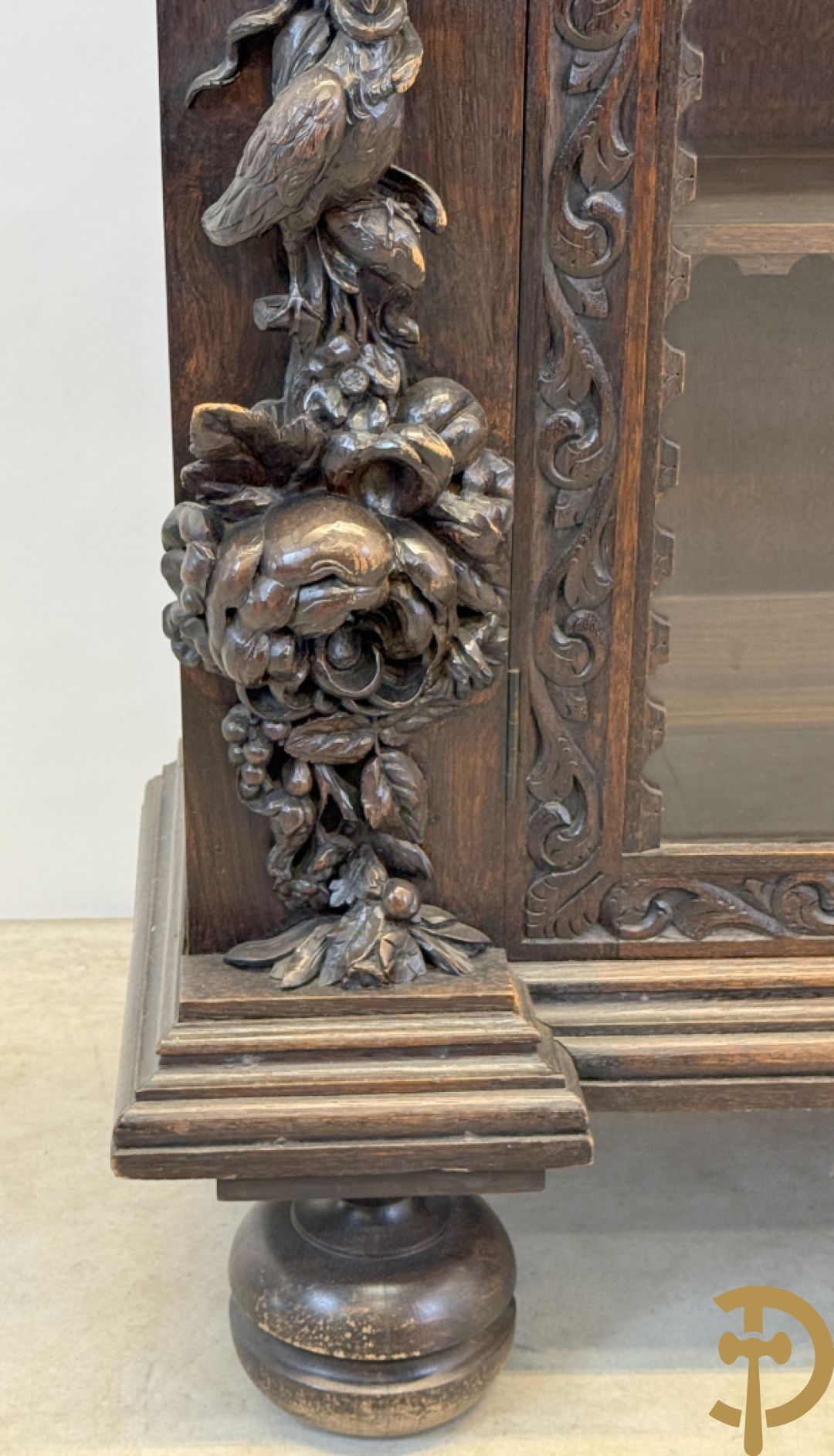 Tweedeursvitrine met Neo Renaissance sculptuur, bovenaan mlet cupidohoofden, bloemen en accanthusranken