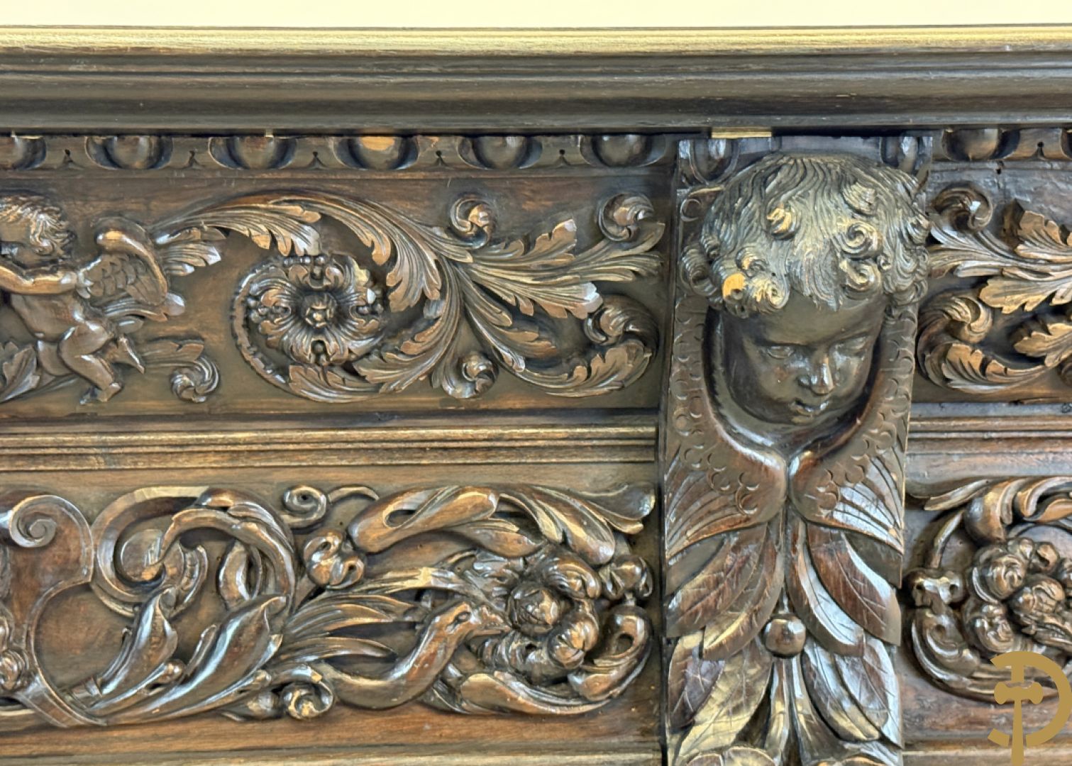 Tweedeursvitrine met Neo Renaissance sculptuur, bovenaan mlet cupidohoofden, bloemen en accanthusranken