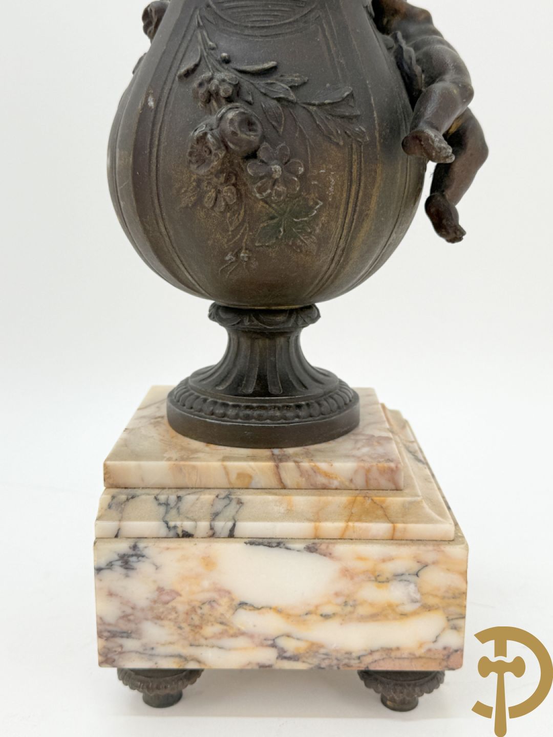 Driedelige kunstbronzen garnituur bestaande uit klok met liggende dame met amfoor op marmeren basis, geflankeerd door paar cassolettes met cupido