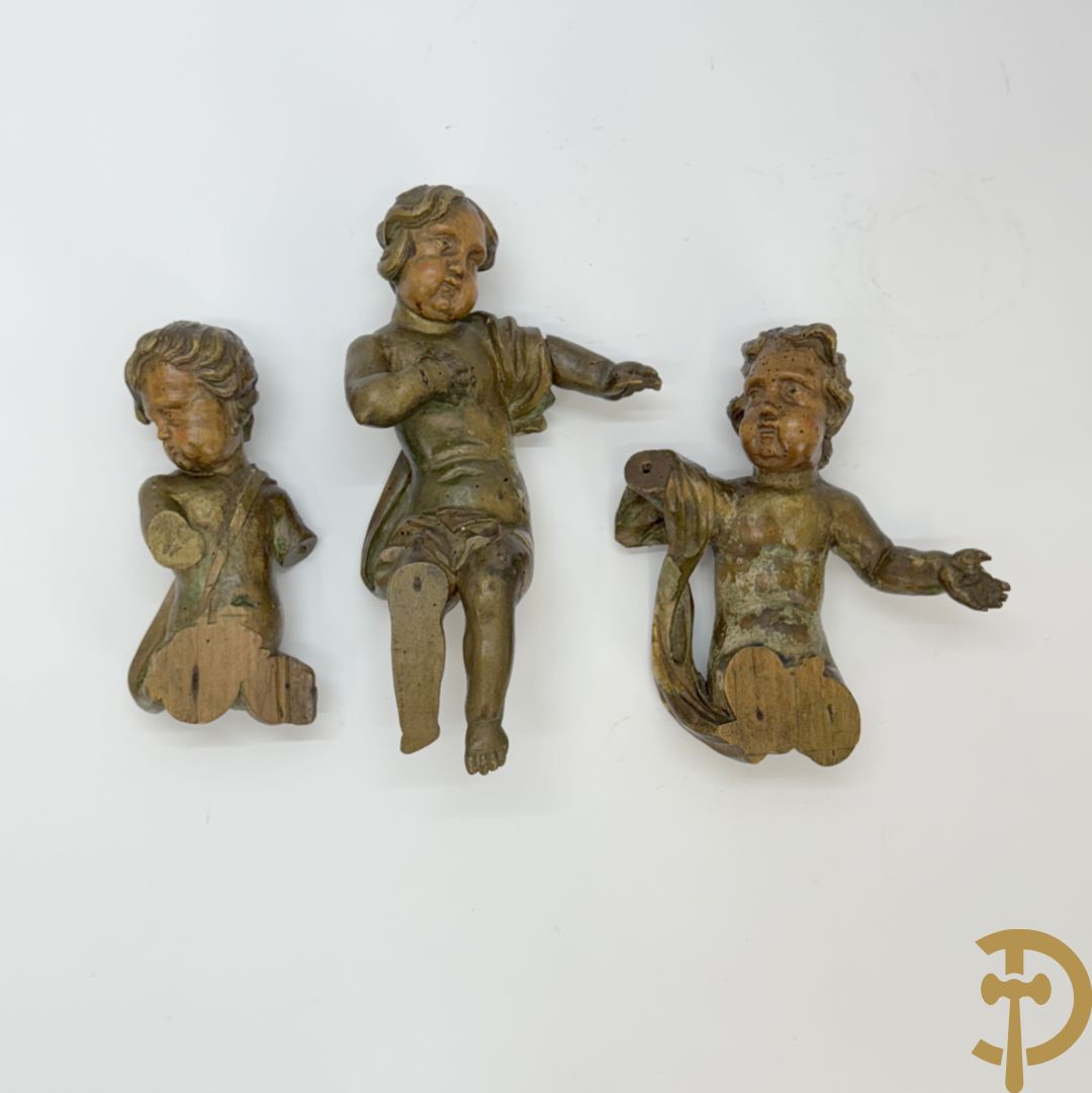 Drie houtgesculpteerde cupido