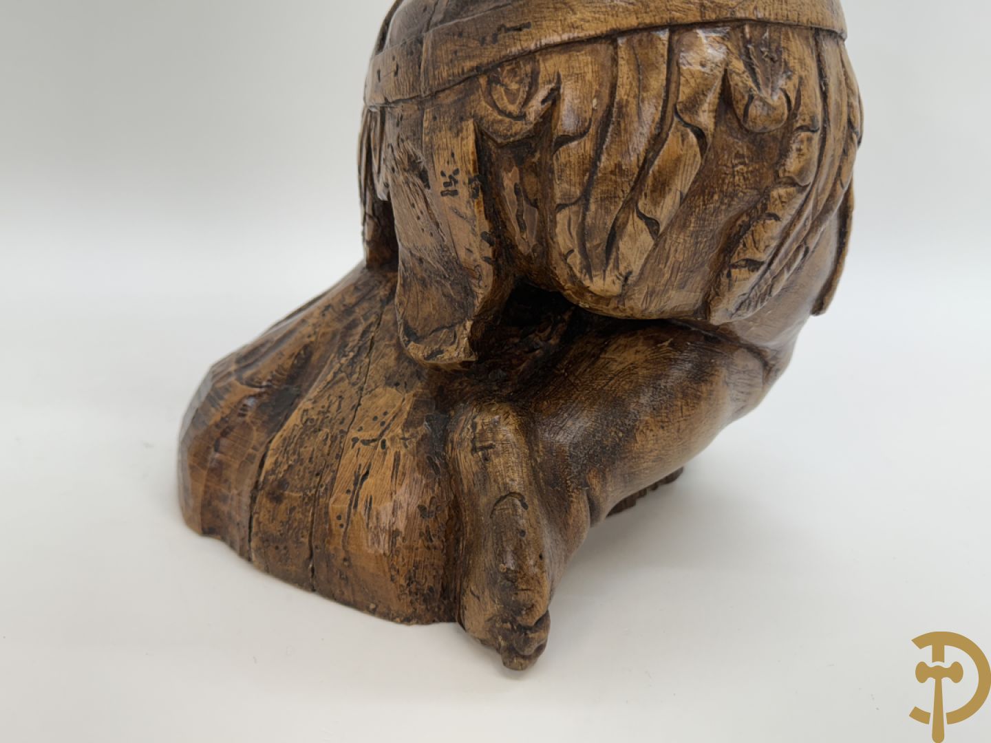Houtgesculpteerde cupido met gevouwen handen en pluimen