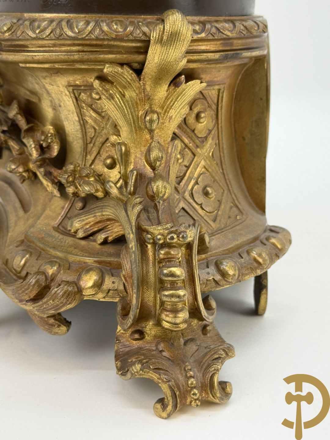 Driedelige bronzen garnituur bestaande uit middenstuk met bronzen vuurvergulde klok, Daubrée gemerkt à Nancy, bovenaan bekroond met Cleopatra met drinkbeker - getekend van Cumberworth sculpteur - geflankeerd door paar cupido