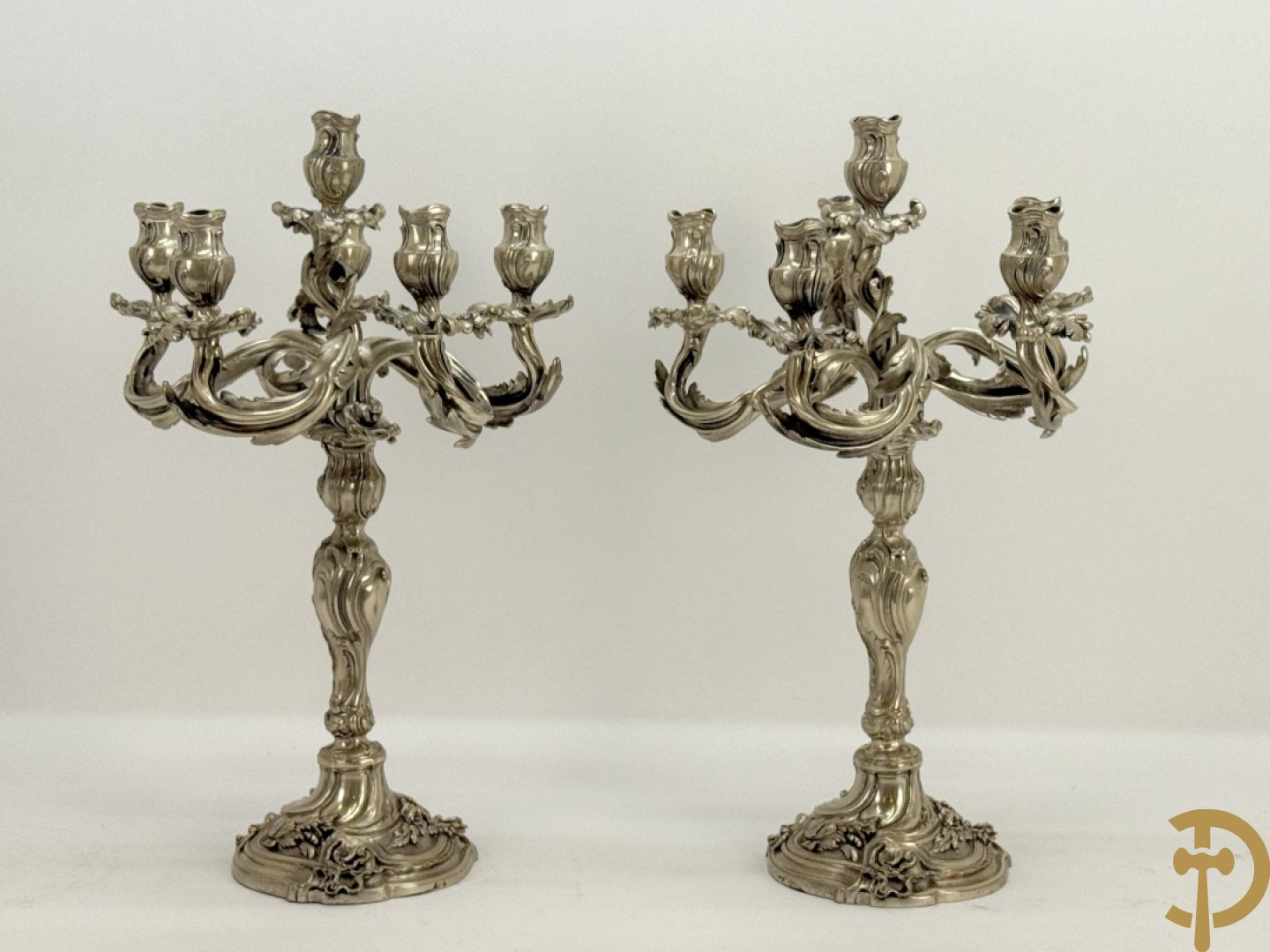 Paar massief zilveren getorste zesarmige kandelaars met Louis XV motieven, met import stempel 