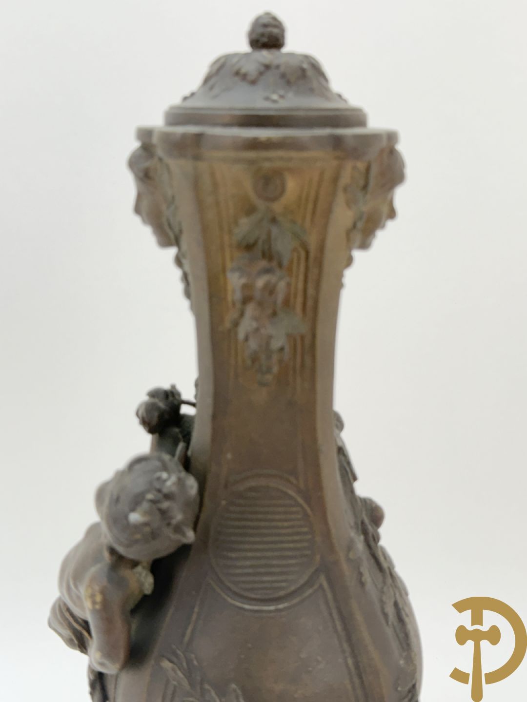Driedelige kunstbronzen garnituur bestaande uit klok met liggende dame met amfoor op marmeren basis, geflankeerd door paar cassolettes met cupido