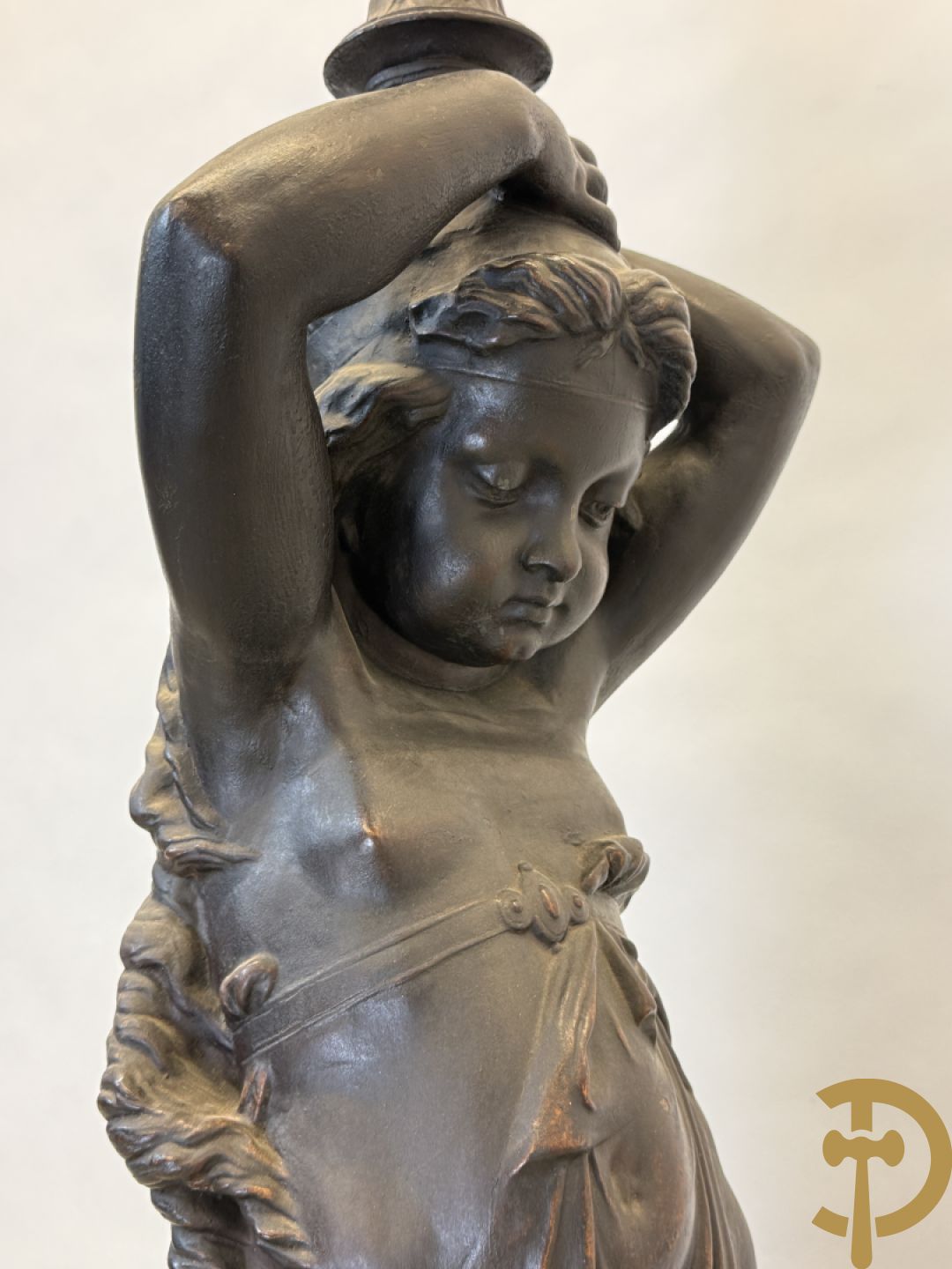 Gietijzeren gepatineerd beeld van cupido dragende een amfoor op het hoofd als lantaarn