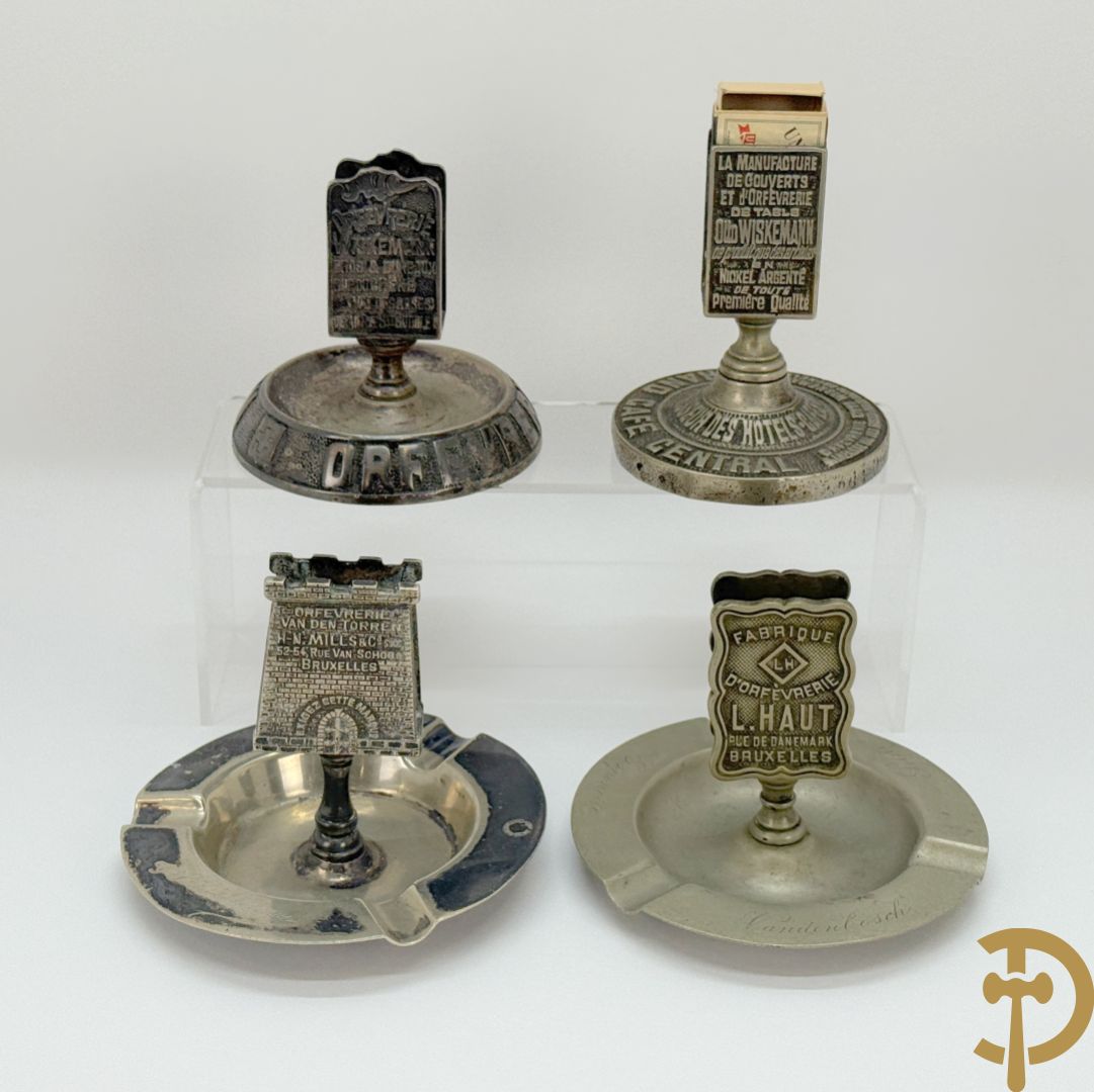 Vier luciferhouders in verzilverd metalen met reclame opschriften van Wiskeman (2 x) , Orfeverie Van Den Torren en Orfeverie L. Haut