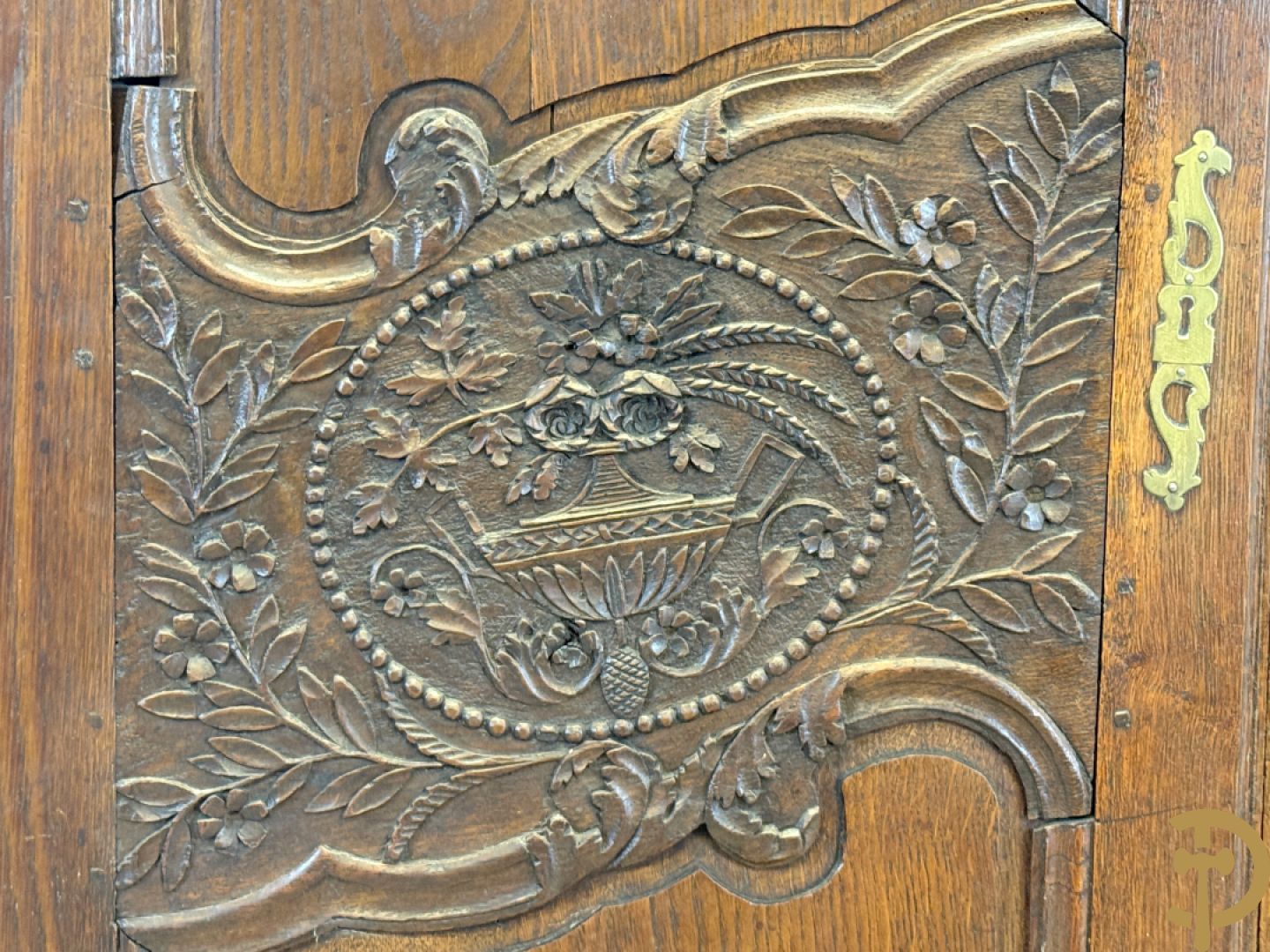 Massief eiken bruidskast met bloemensculptuur opzij, accanthusranken en bekroond met bloemenkorf