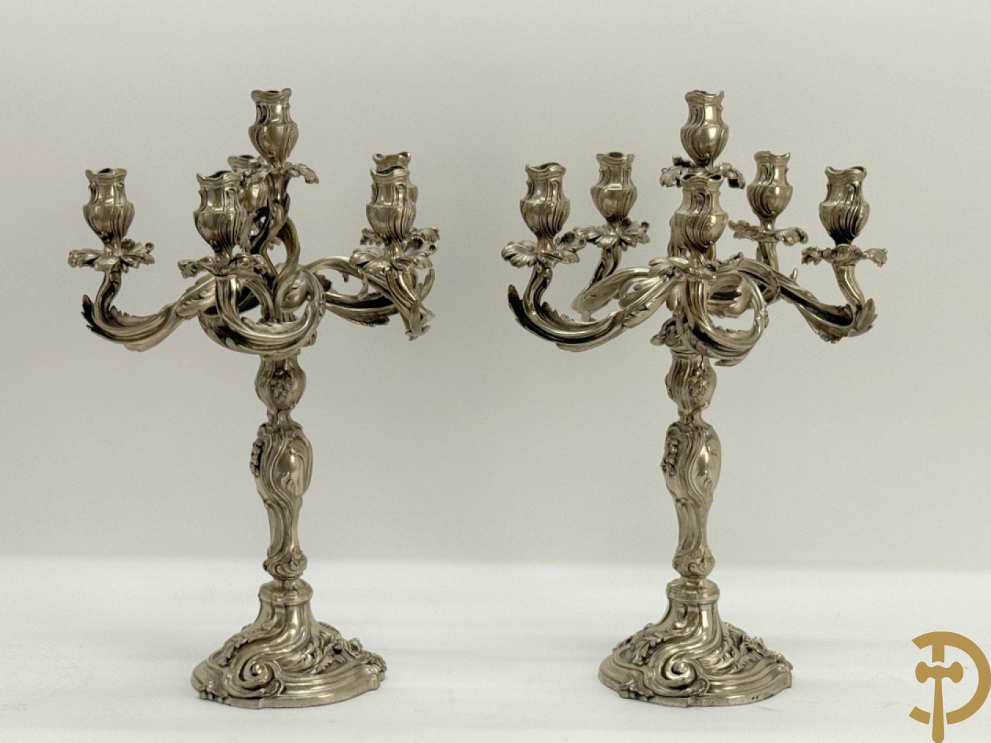 Paar massief zilveren getorste zesarmige kandelaars met Louis XV motieven, met import stempel 