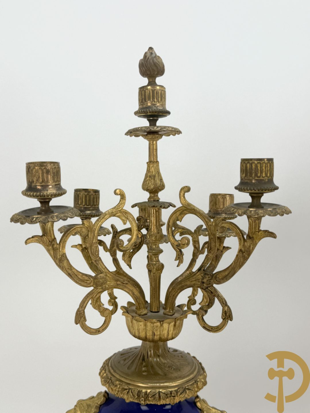 Driedelige vergulde bronzen garnituur bestaande uit pendule met blauw porseleinen coupe geflankeerd door 2 cupido