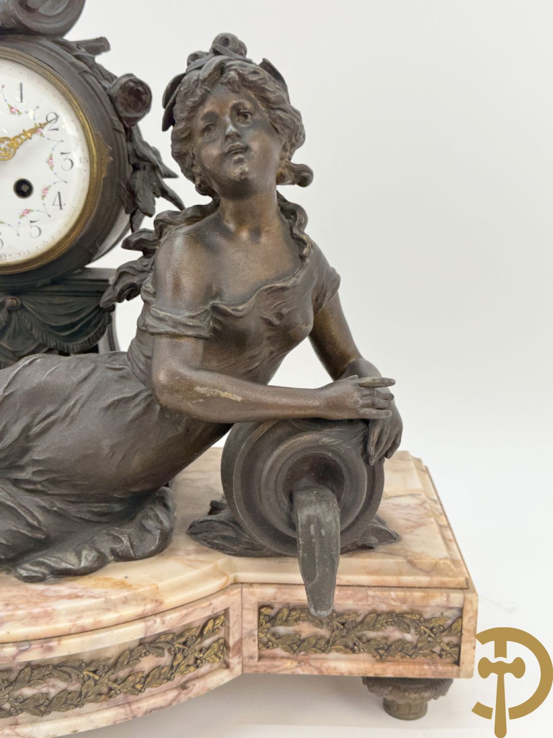Driedelige kunstbronzen garnituur bestaande uit klok met liggende dame met amfoor op marmeren basis, geflankeerd door paar cassolettes met cupido