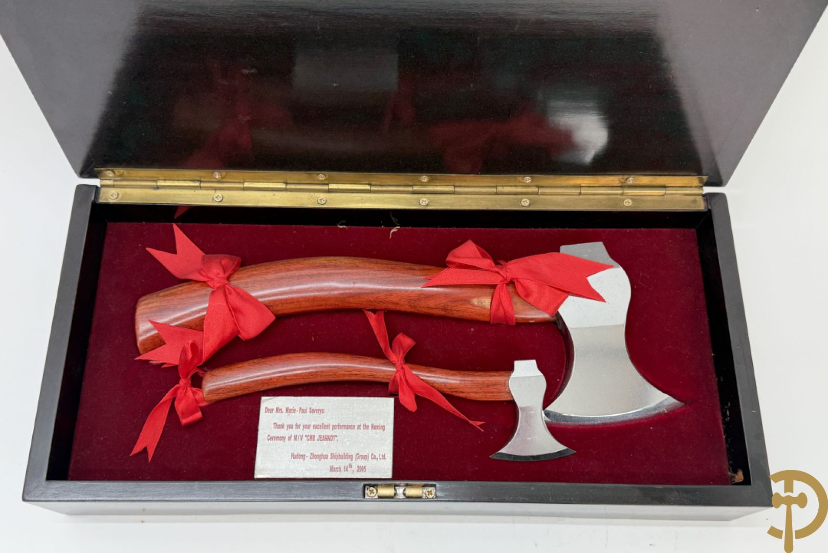 Paar bijltjes ter gelegenheid van inhuldiging van een schip in houten kistje met decoratie van oosterse boot, Dear Mrs. Marie-Paul Saverys : Thank you for your performance et the Naming Ceremony of M/V "CMB Jeannot" Hudong - Zhonghua Shipbuilding (Group) Co., L.M., March 14th, 2005