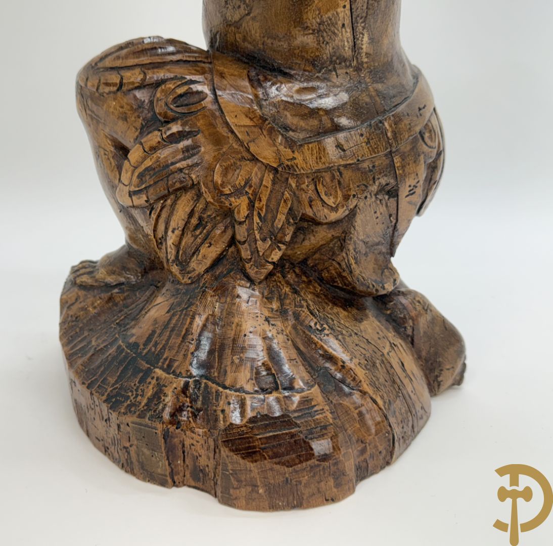 Houtgesculpteerde cupido met gevouwen handen en pluimen