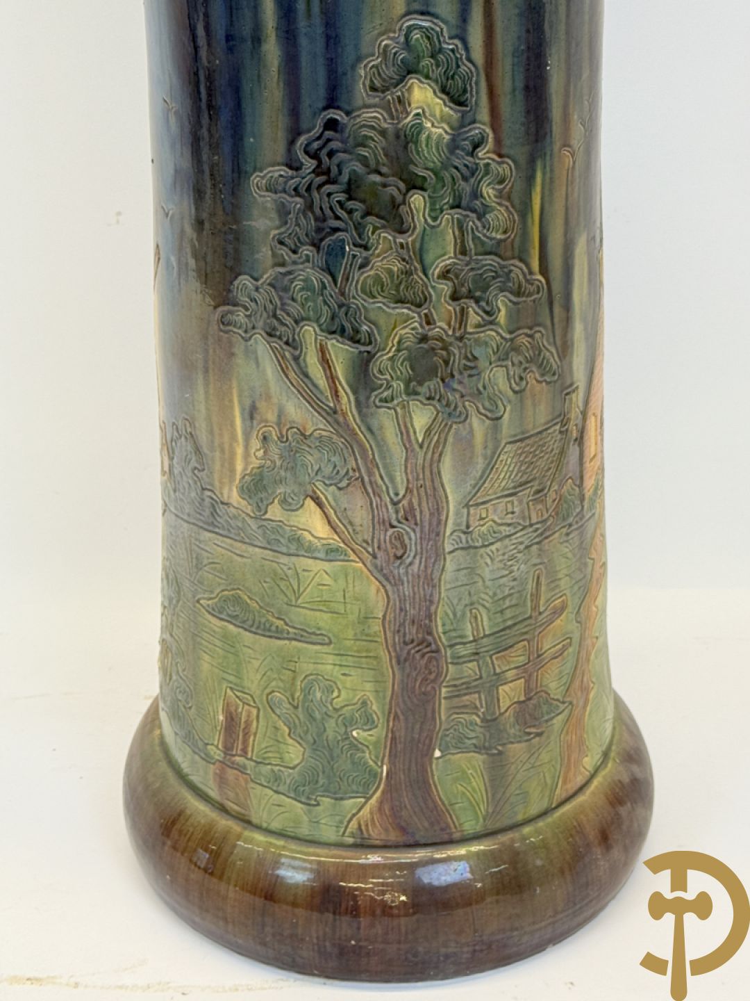 Vlaams aardewerken cachepot op zuil, bovenaan met bloemendecor en onderaan met decor van huizen, bomen en kerkzicht