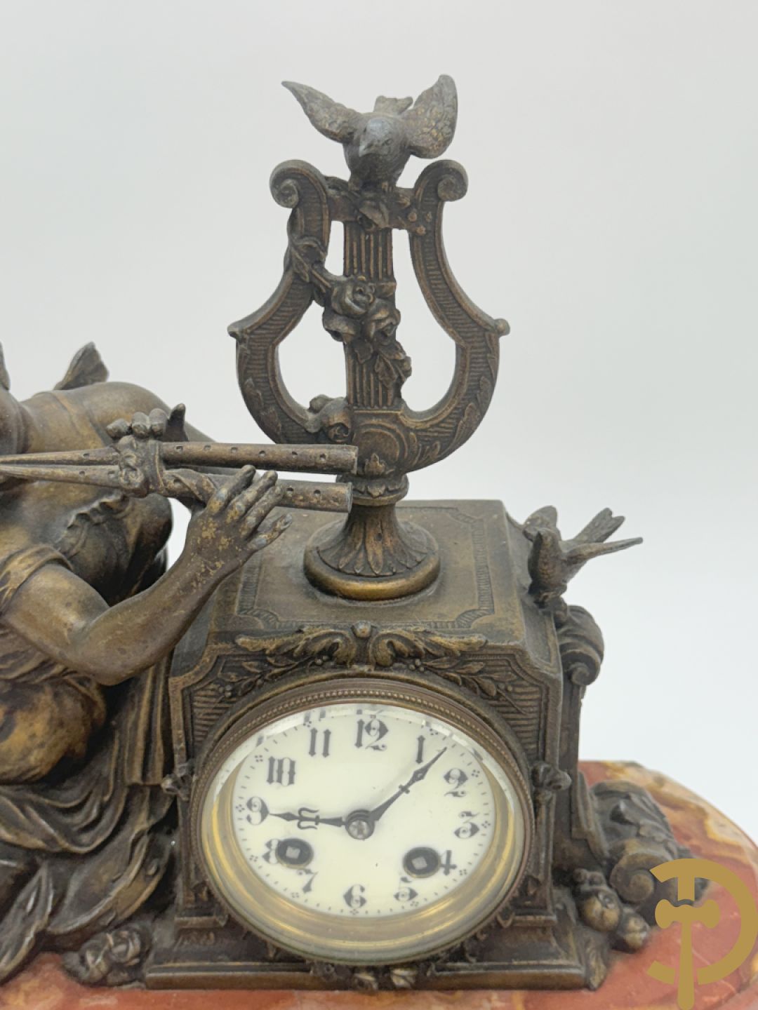 Driedelige garnituur, centraal horloge gedecoreerd met zamak beeld van fluitspelende cupido, geflankeerd door paar cassolettes - alles op marmeren basis