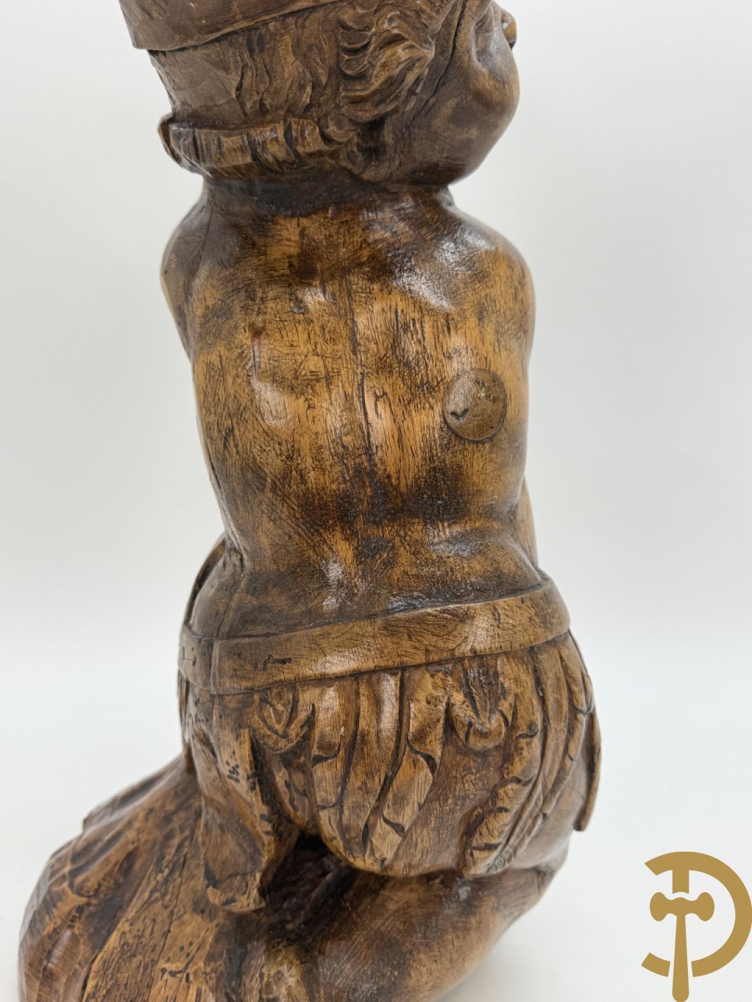 Houtgesculpteerde cupido met gevouwen handen en pluimen
