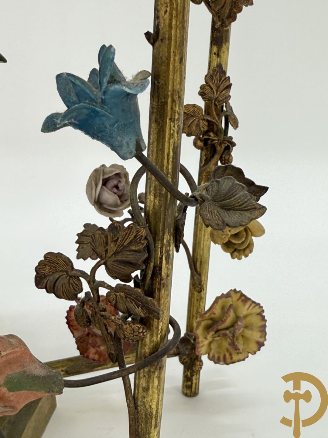 Handgekleurde porseleinen papegaai onder koperen boog met bloemen bezet, als lampadaire