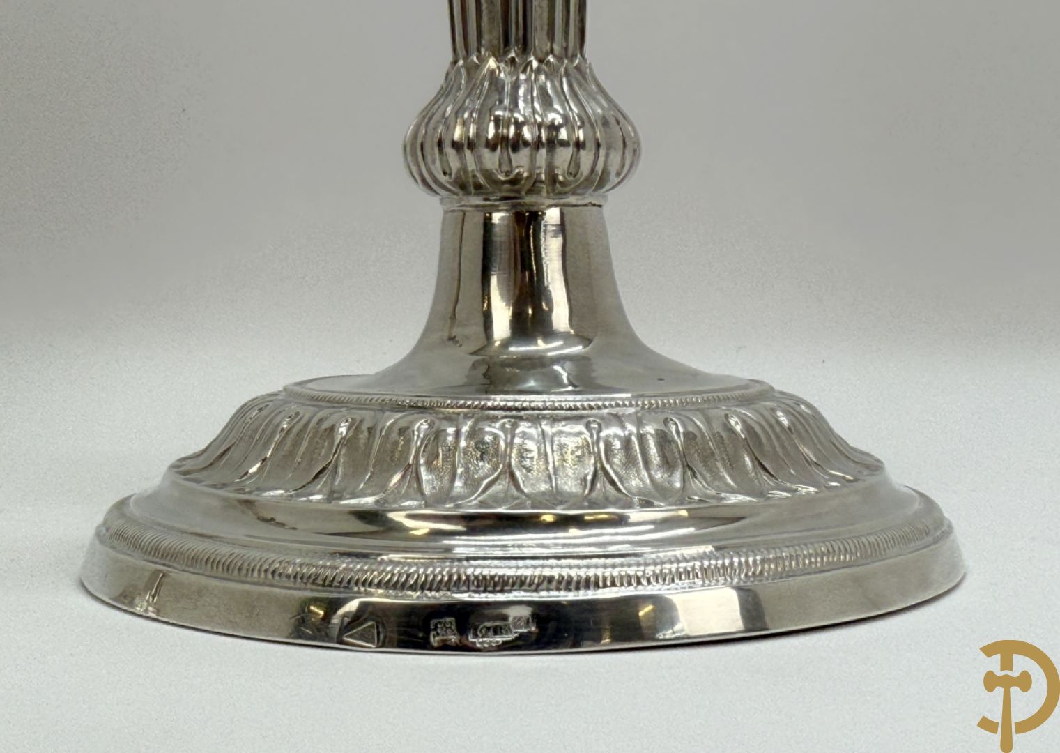 Paar massief zilveren kandelaars met gestyleerd bloemenmotief, één ervan gemerkt met stempel van Jan Baptist Verberckt, andere kandelaar met verschillende stempels met o.a. Antwerpen 1784