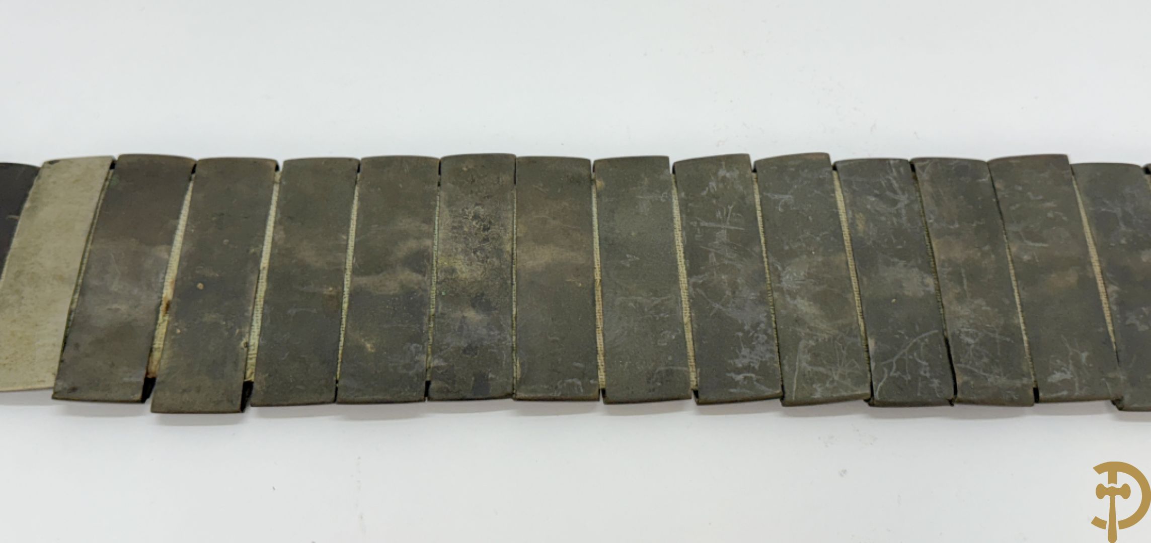 Gekleurde metalen riem met koperen lemmetten en bronzen sluiting