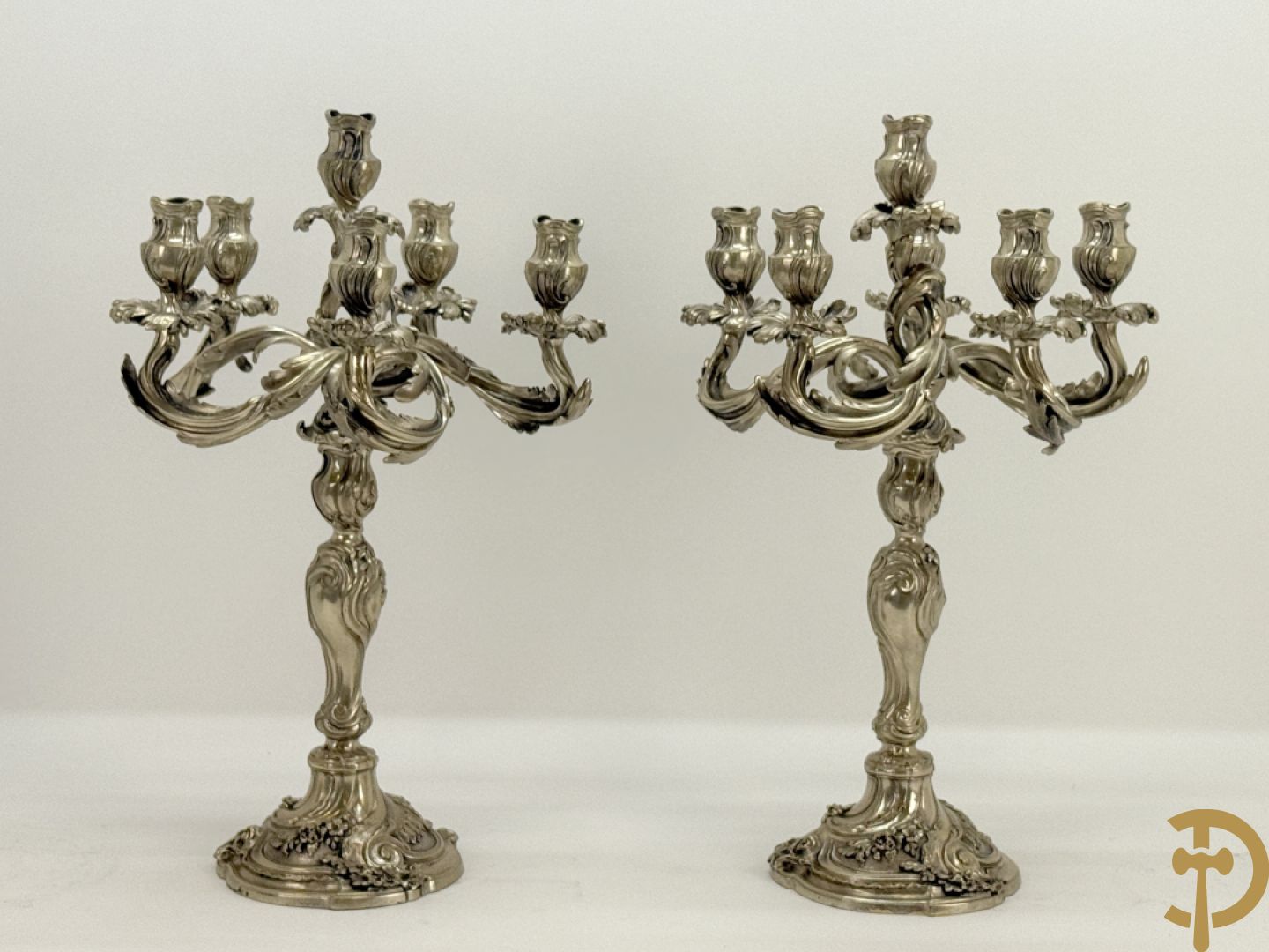Paar massief zilveren getorste zesarmige kandelaars met Louis XV motieven, met import stempel 
